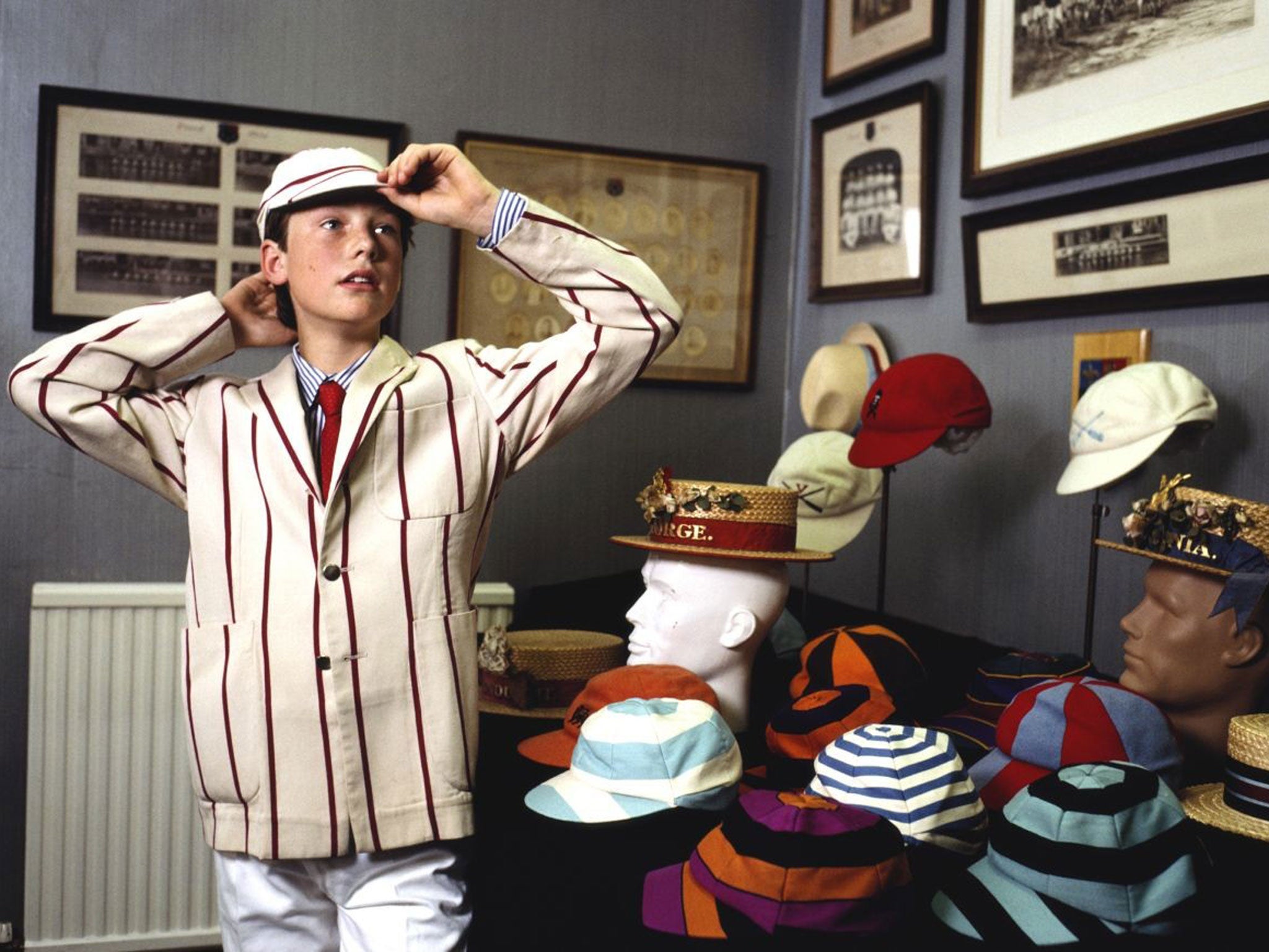 A boy bound for a private school tries on a striped cap