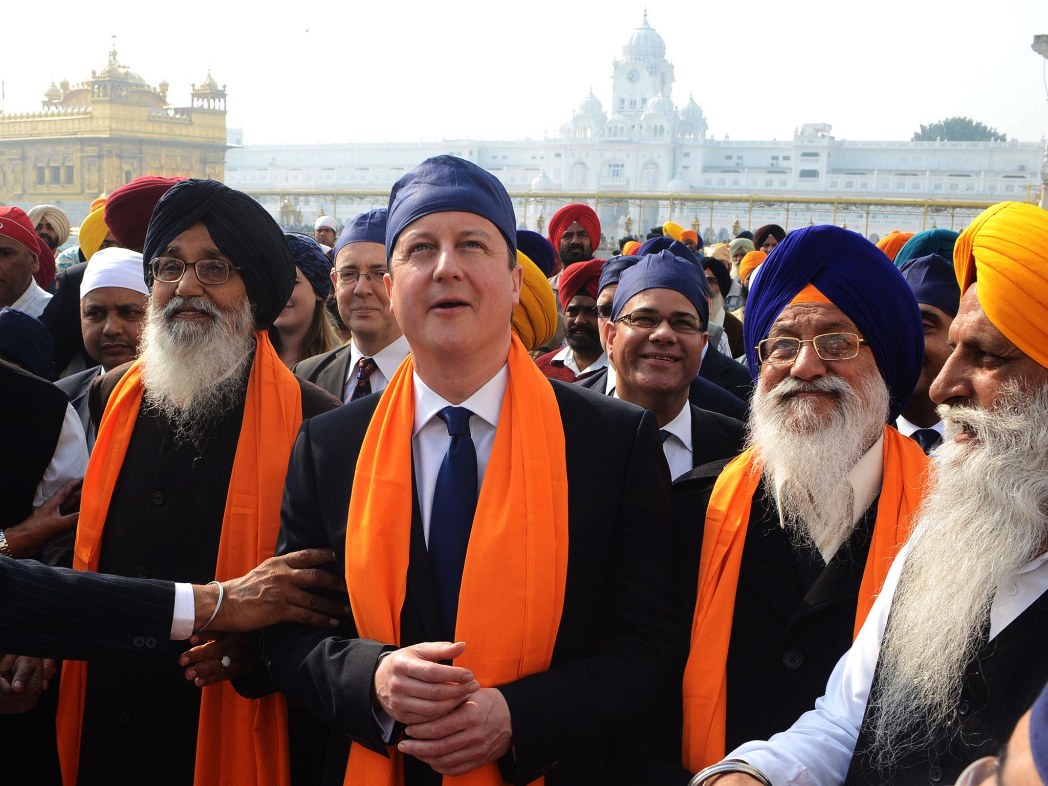 British Prime Minister David Cameron along with Punjab State Chief Minister Parkash Singh Badal (2L), and Shiromani Gurdwara Parbandhak Committee (SGPC) President Avtar Singh Makkar (2R) visit the Sikh Shrine Golden temple in Amritsar