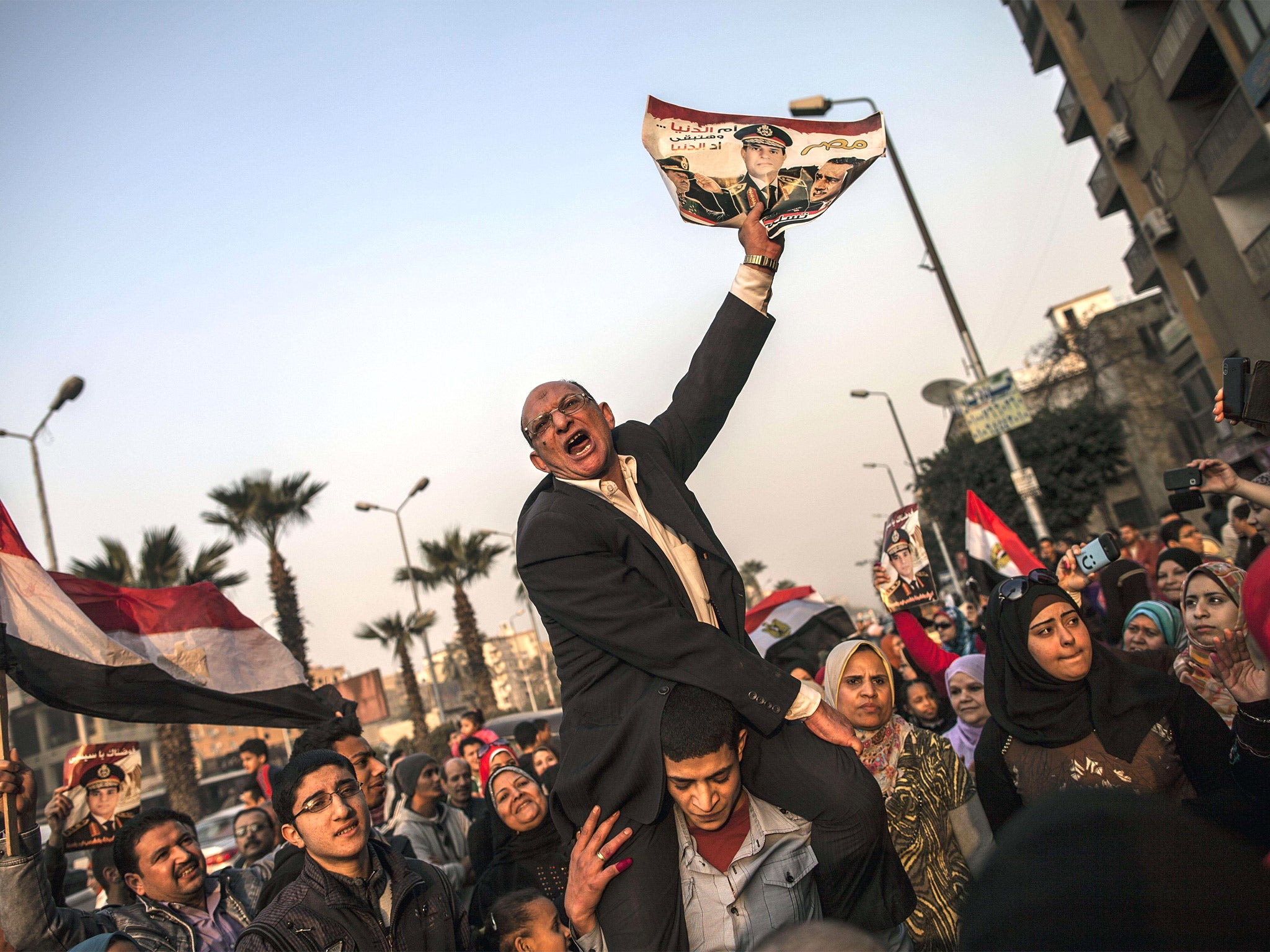 A picture of General Sisi is held aloft at a polling station in Cairo