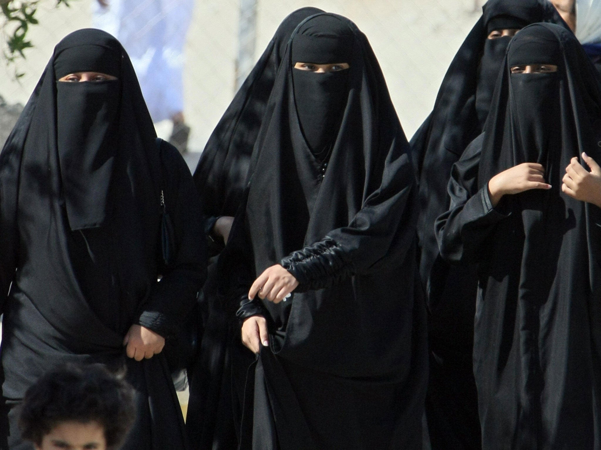 Saudi women cross a street in Hofuf city