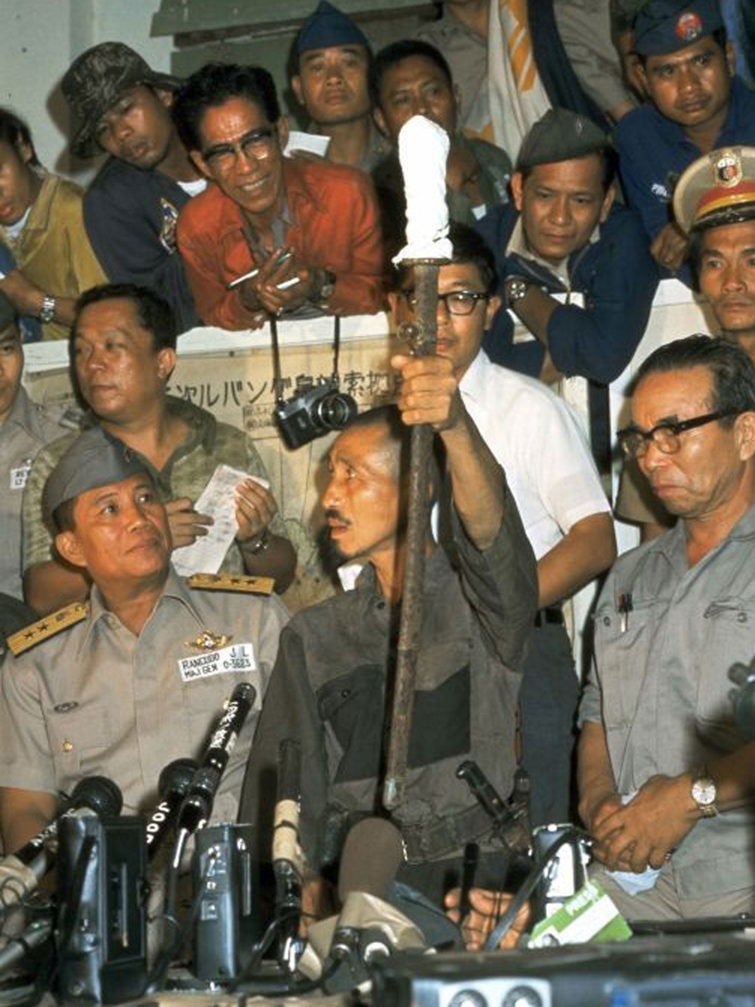 Former Japanese Imerial Army intelligent officer Hiroo Onoda (C) shows his Japanese sword during a press conference on March 10, 1974 in Lubang, Philippines. Leutinant Onoda, who spent almost 30-years holding out in the jungle on the Philippine island of