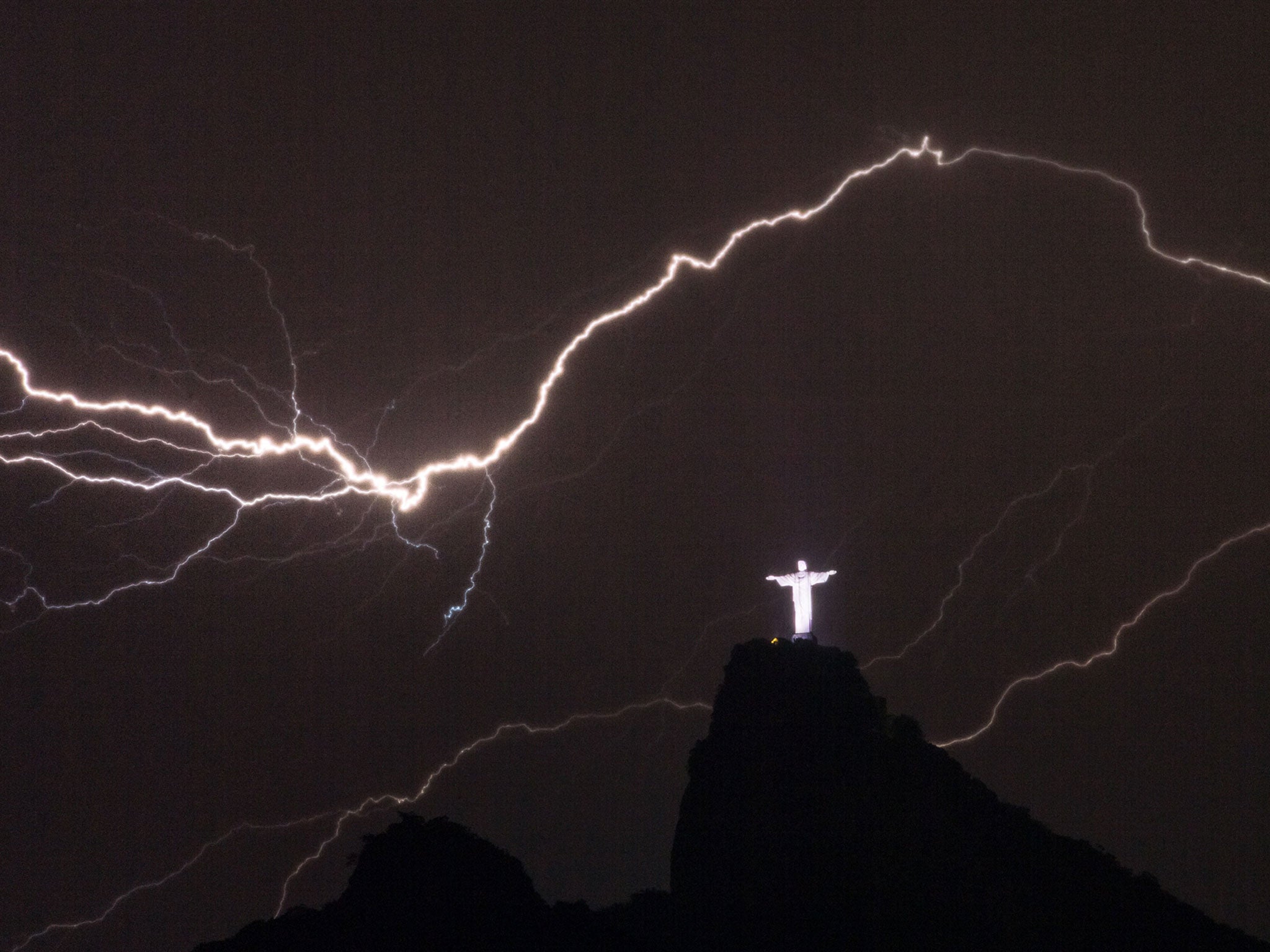 Lightning flashes over the Christ the Redeemer statue on top of Corcovado Hill in Rio de Janeiro on January 14, 2014.