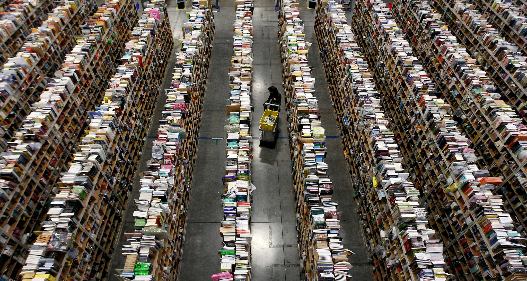 A worker gathers items for delivery from the warehouse floor at Amazon's distribution center in Phoenix, Arizona.