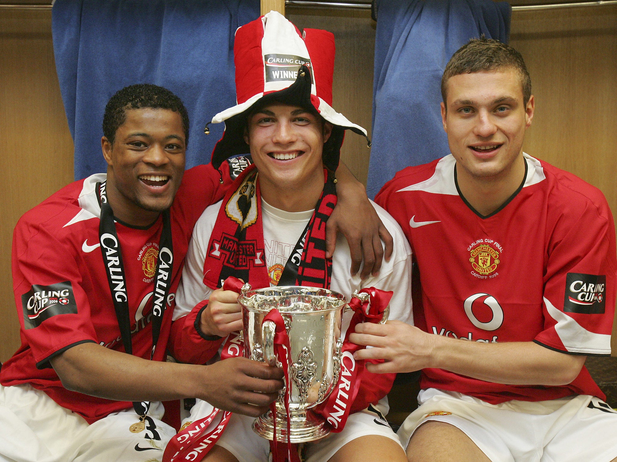 Patrice Evra, Cristiano Ronaldo and Nemanja Vidic of Manchester United pose with the Carling Cup trophy in the dressing room after their 2006 win