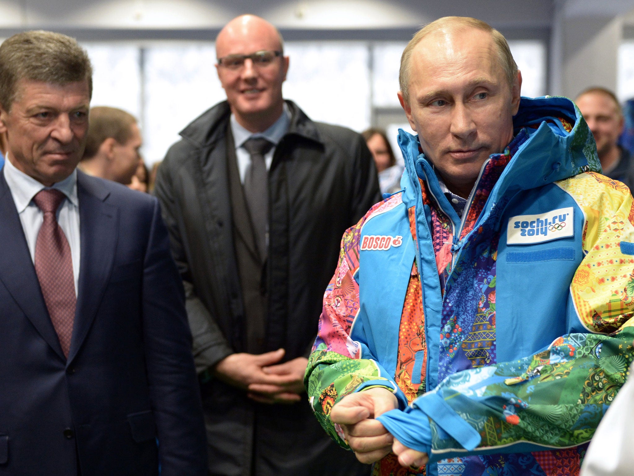 The Russian President Vladimir Putin tries on a Sochi volunteer's uniform