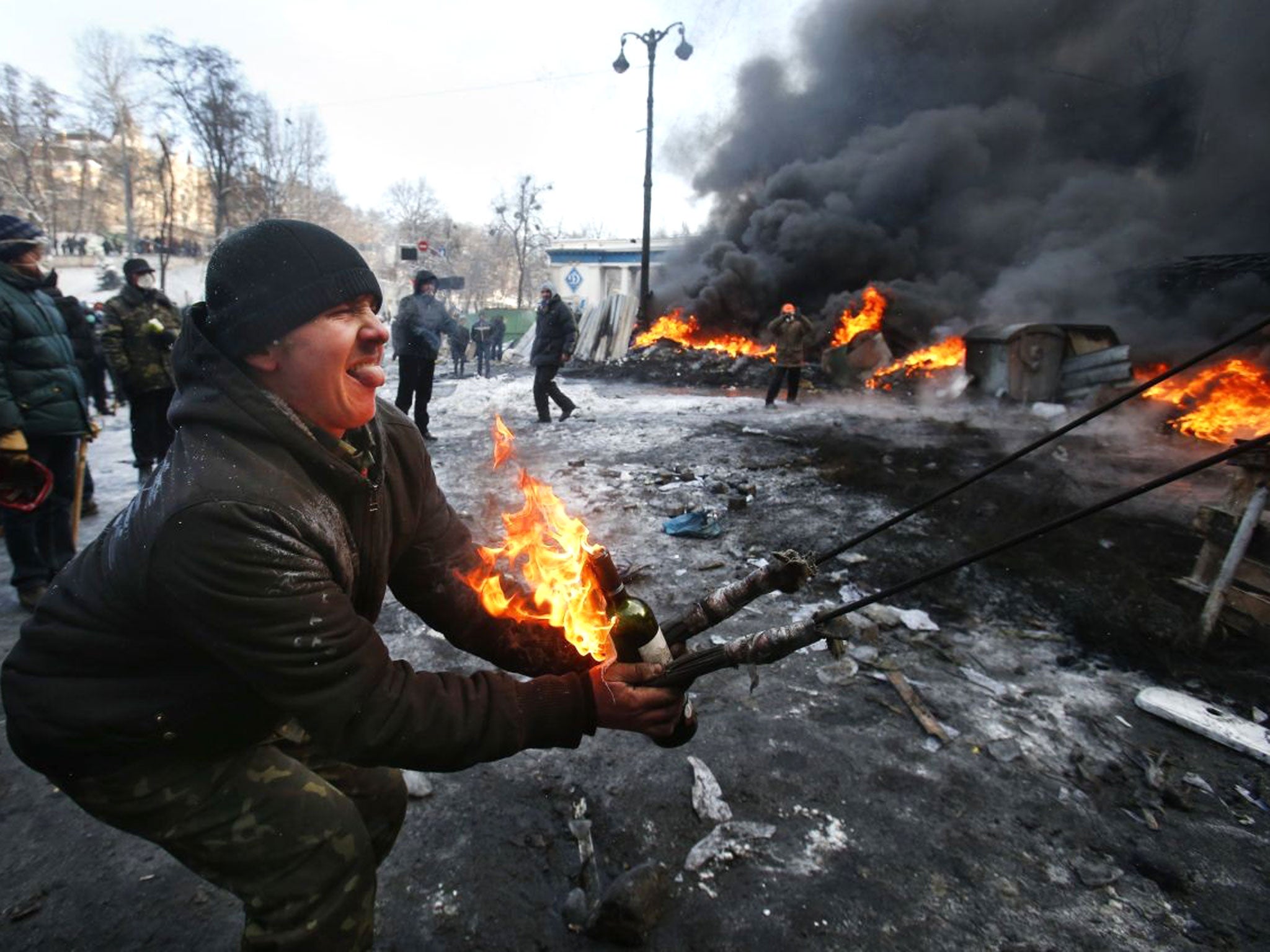 Protesters use a large slingshot to hurl a Molotov cocktail at police in central Kiev