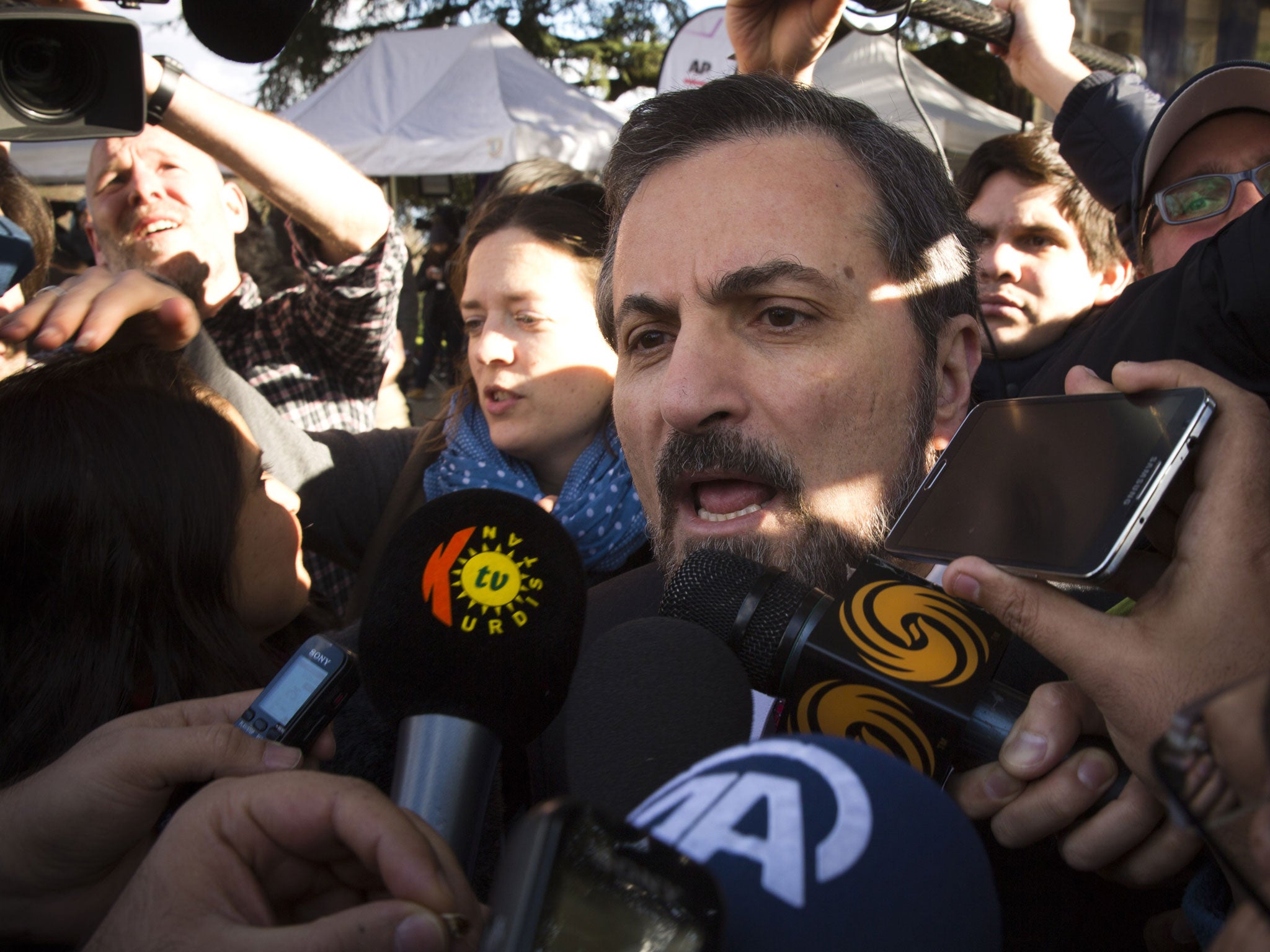 Louay Safi is surrounded by journalists as he arrives to the United Nations headquarters in Geneva (AP)