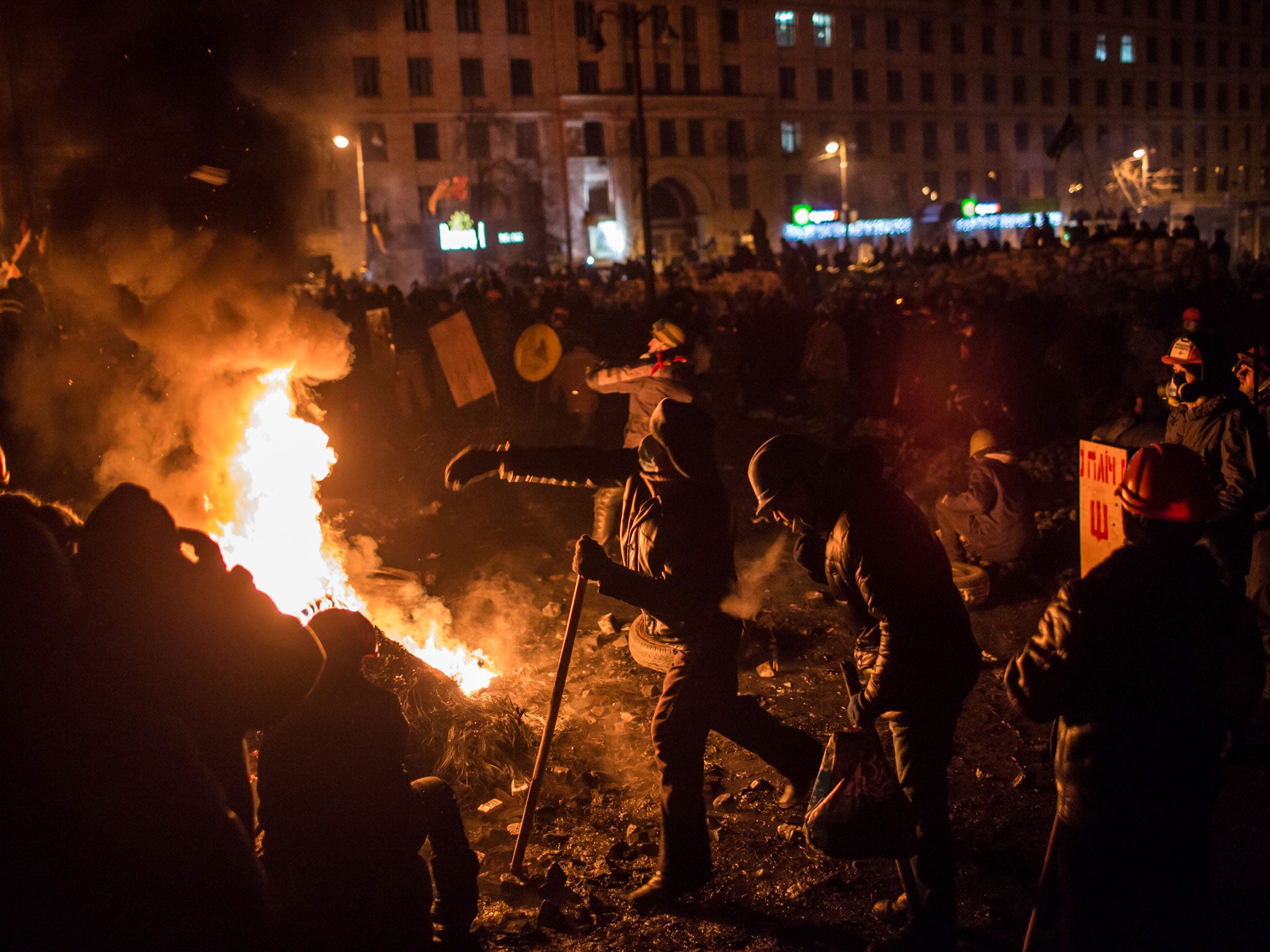 Anti-government protesters hurl Molotov cocktails and burn tires during clashes with police on Hrushevskoho Street