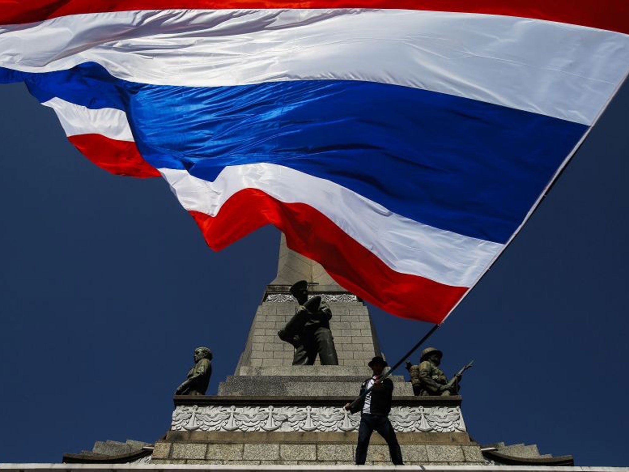 Flag up: An anti-government protester in Bangkok earlier this month