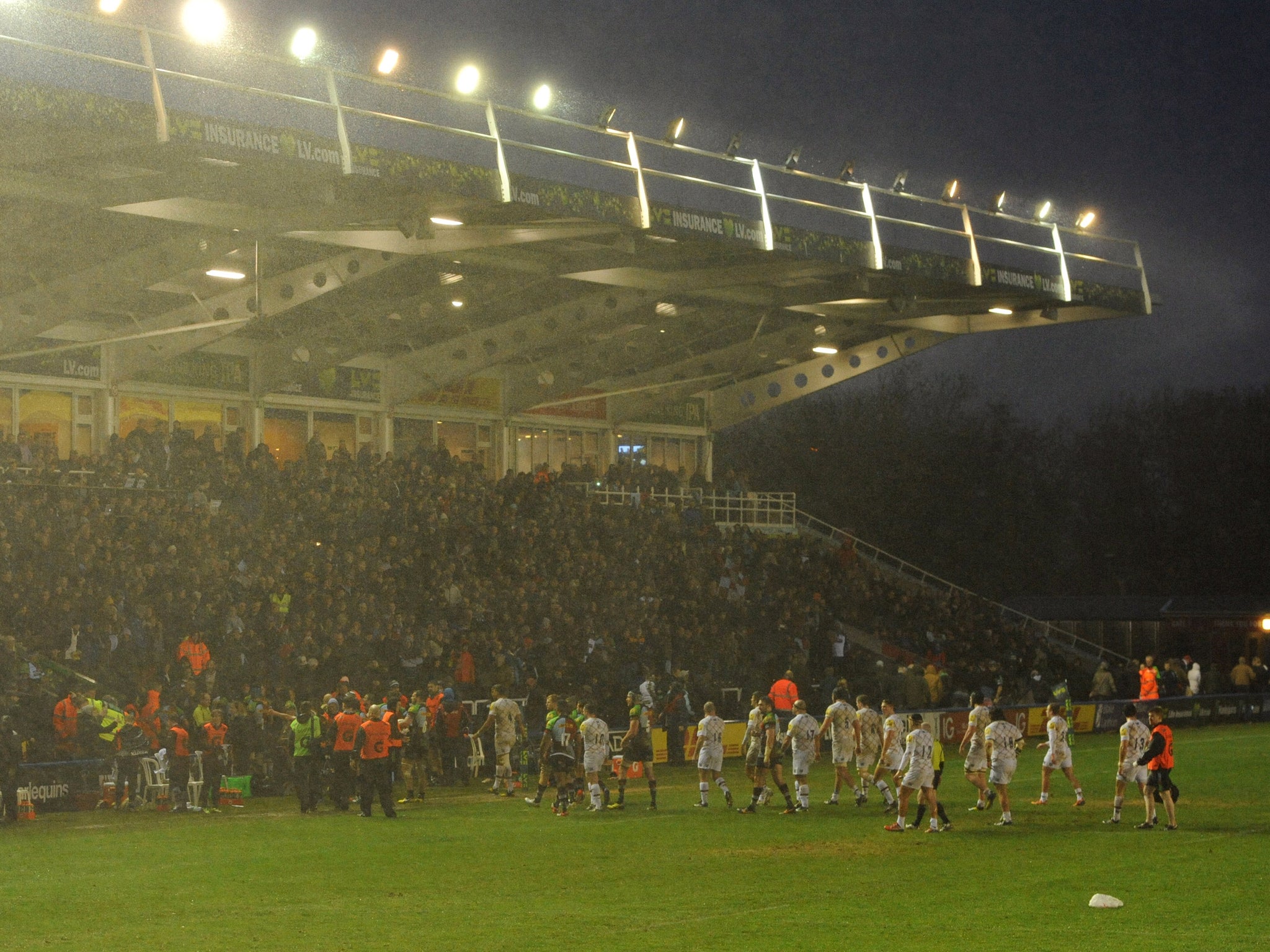 Harlequins and Leicester Tigers players leave the Twickenham Stoop pitch after the game is stopped on 'health and safety grounds'