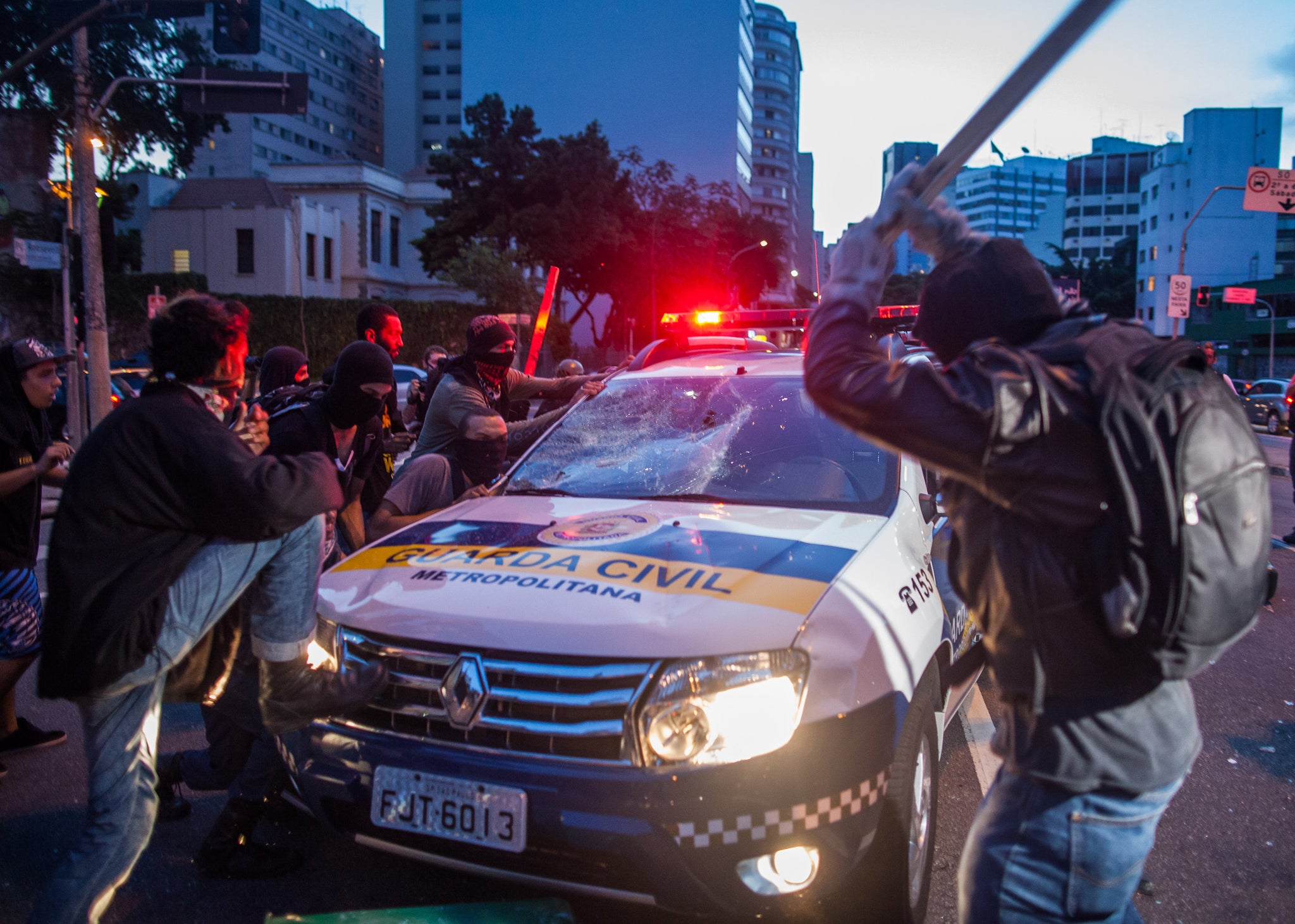 Protesters smash a police car during the protest