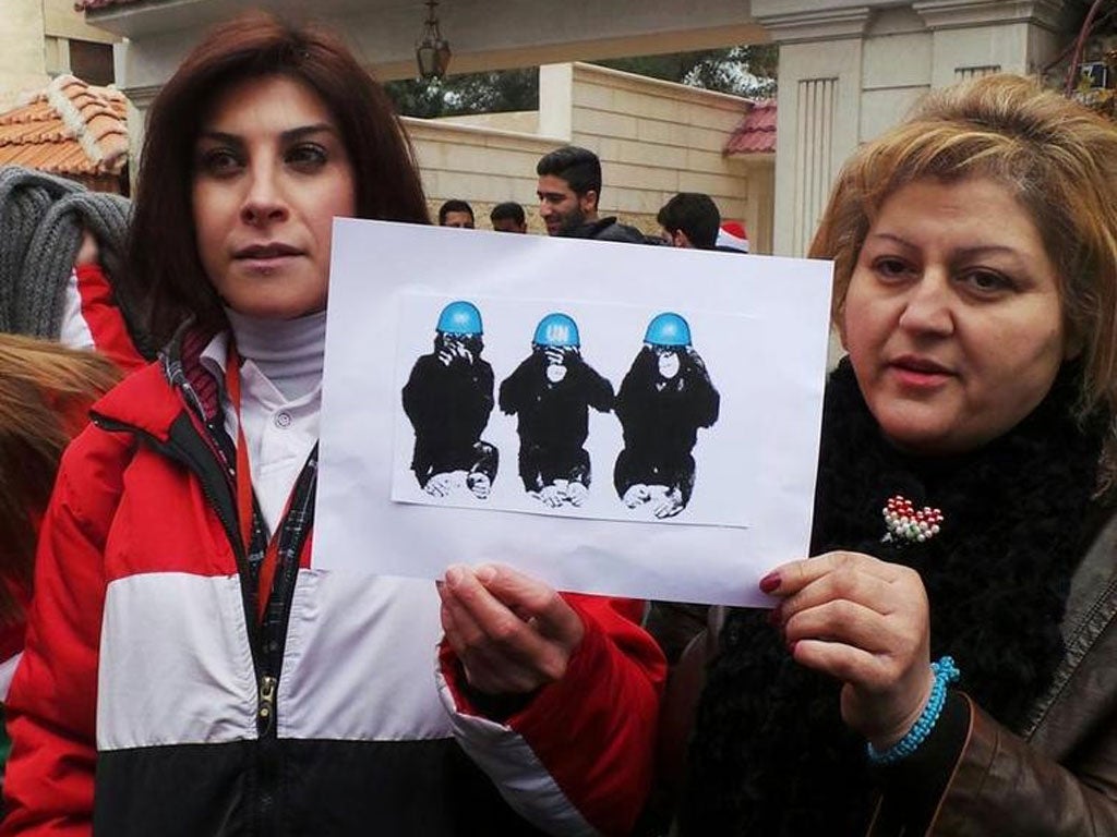 Pro-Assad demonstrators in front of the United Nations headquarters in Damascus, protesting against what they said is the UN inaction over the situation in Adra (Reuters)