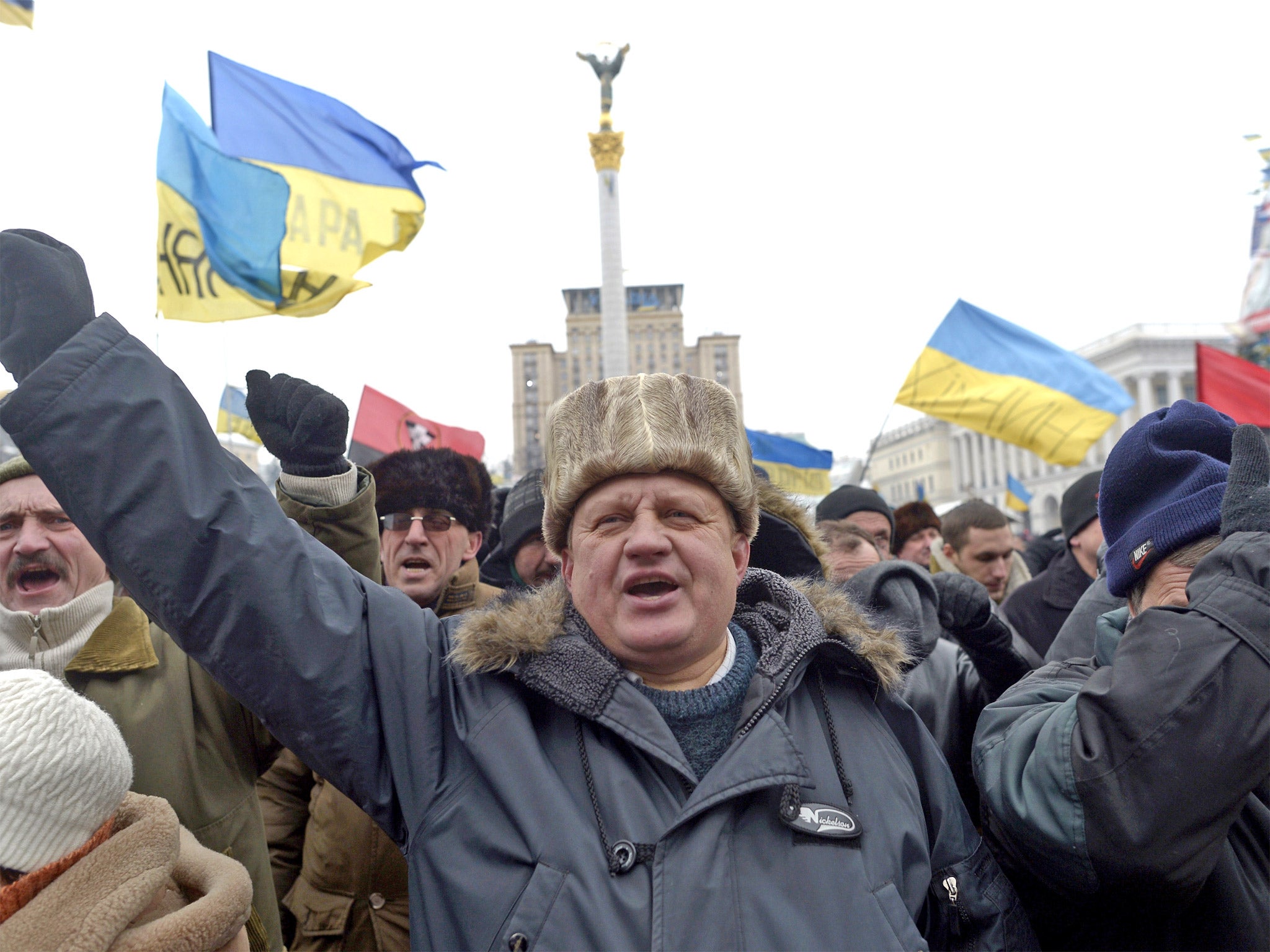 An anti-government protester raises his fist during a protest on Independence Square in Kiev