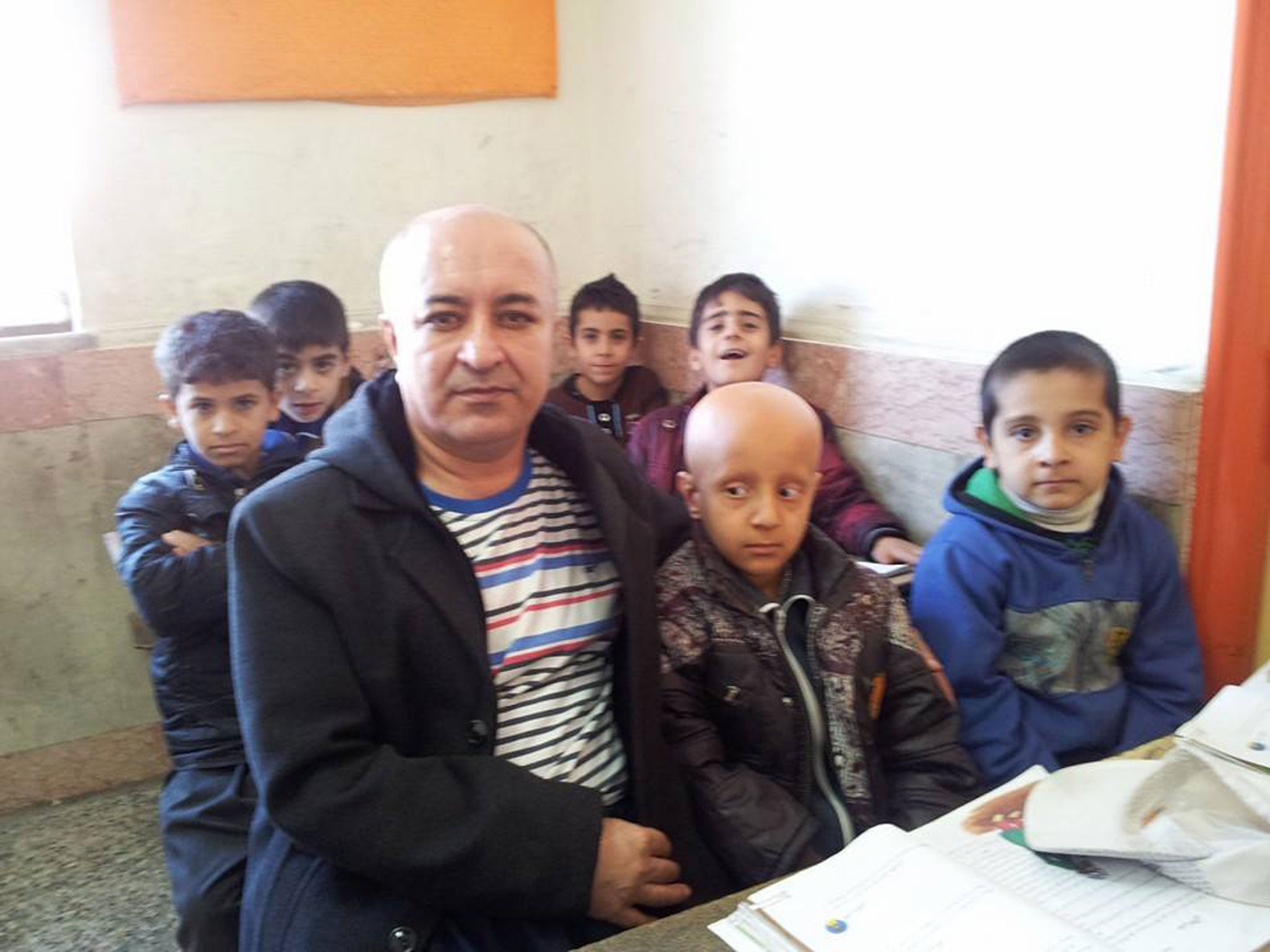 Iranian Teacher Ali Mohammadian with 8-year-old Mahan Rahimi, in a photo taken before Mahan's classmates followed their teacher and also shaved their hair.