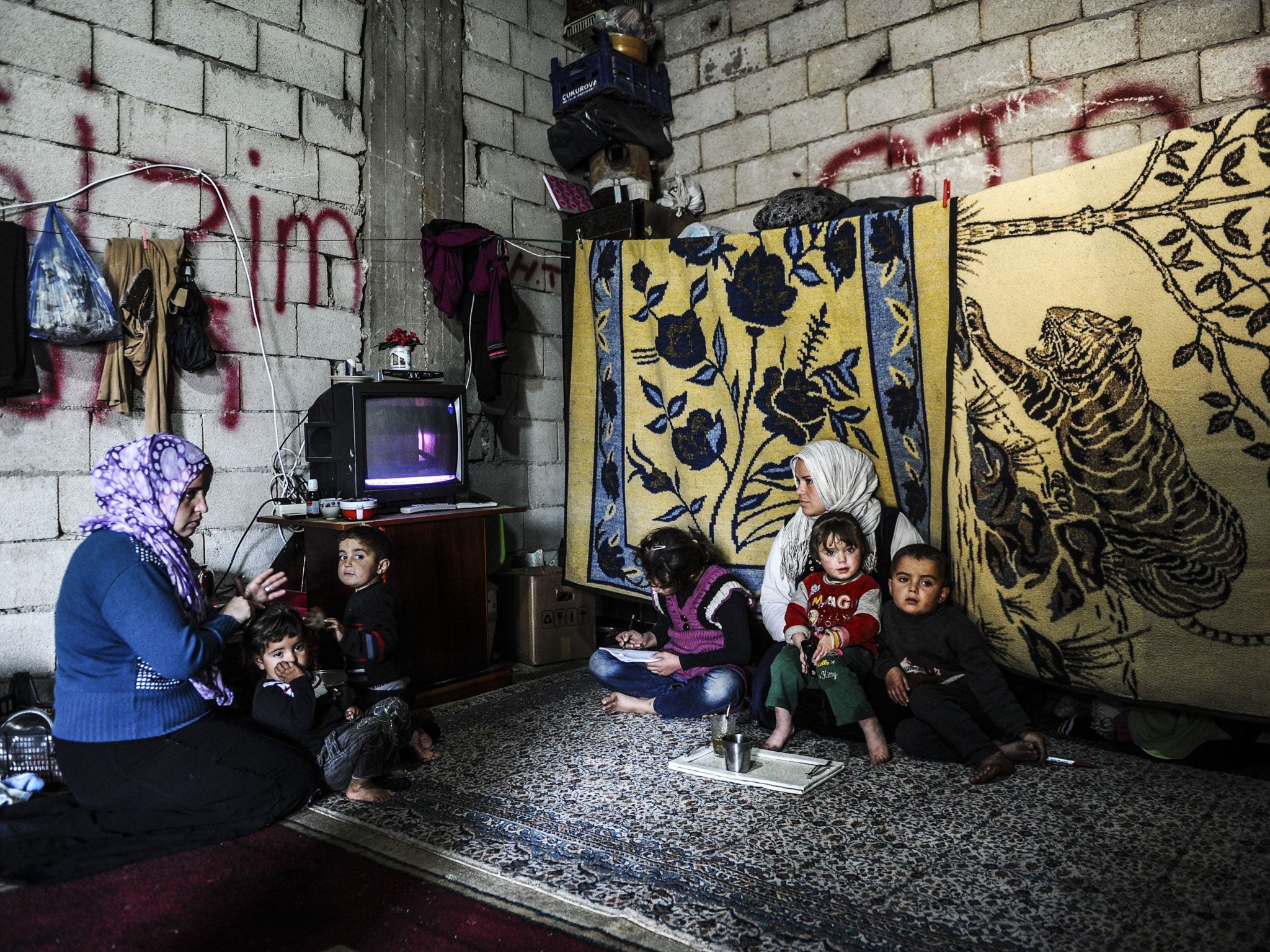 A Syrian refugee family rests inside their shelter in Hatay, Turkey