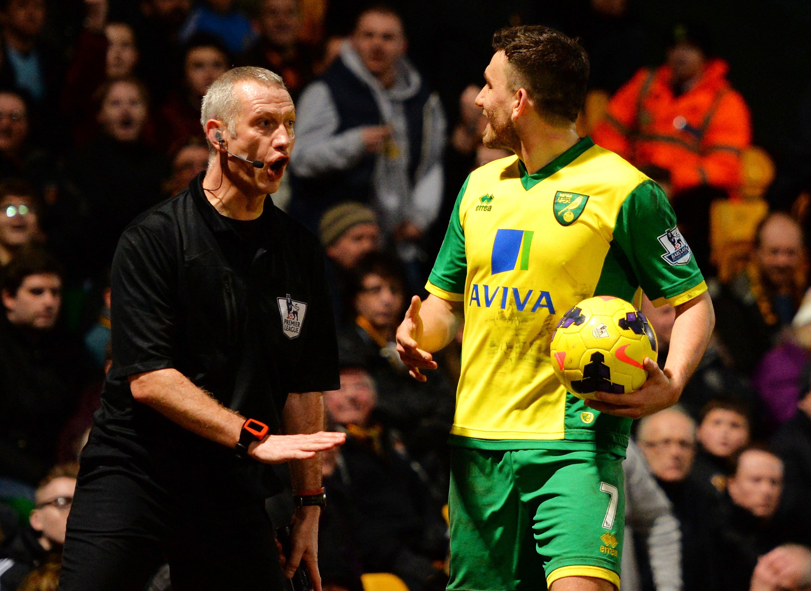 Assitant referee Stuart Burt (left) calms down Robert Snodgrass of Norwich City as he reacts to fans during the Premier League match between Norwich City and Hull