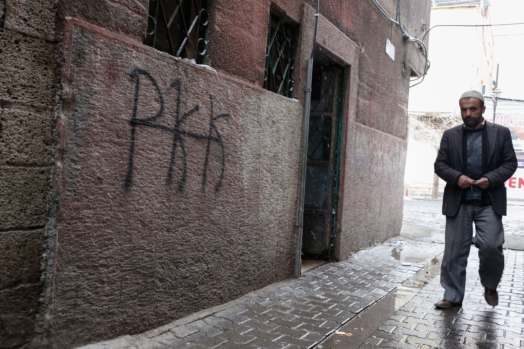 A man walks past graffiti supporting the PKK in Diyabakir's historic backstreets