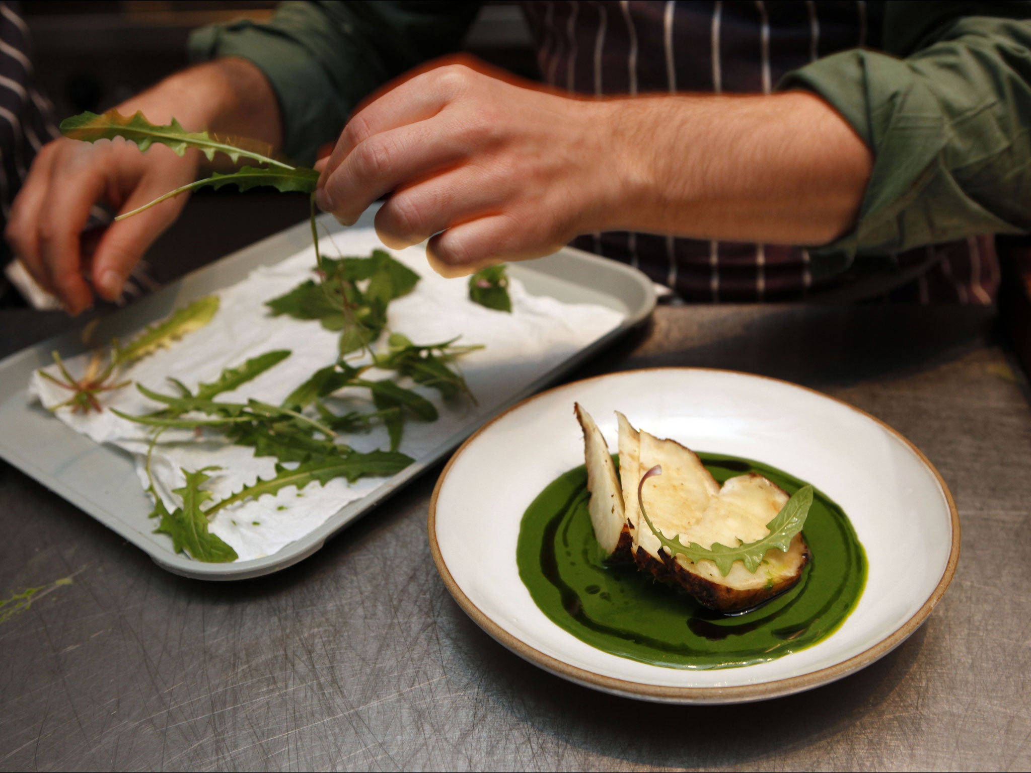 Finishing touches: Redzepi garnishes his dish