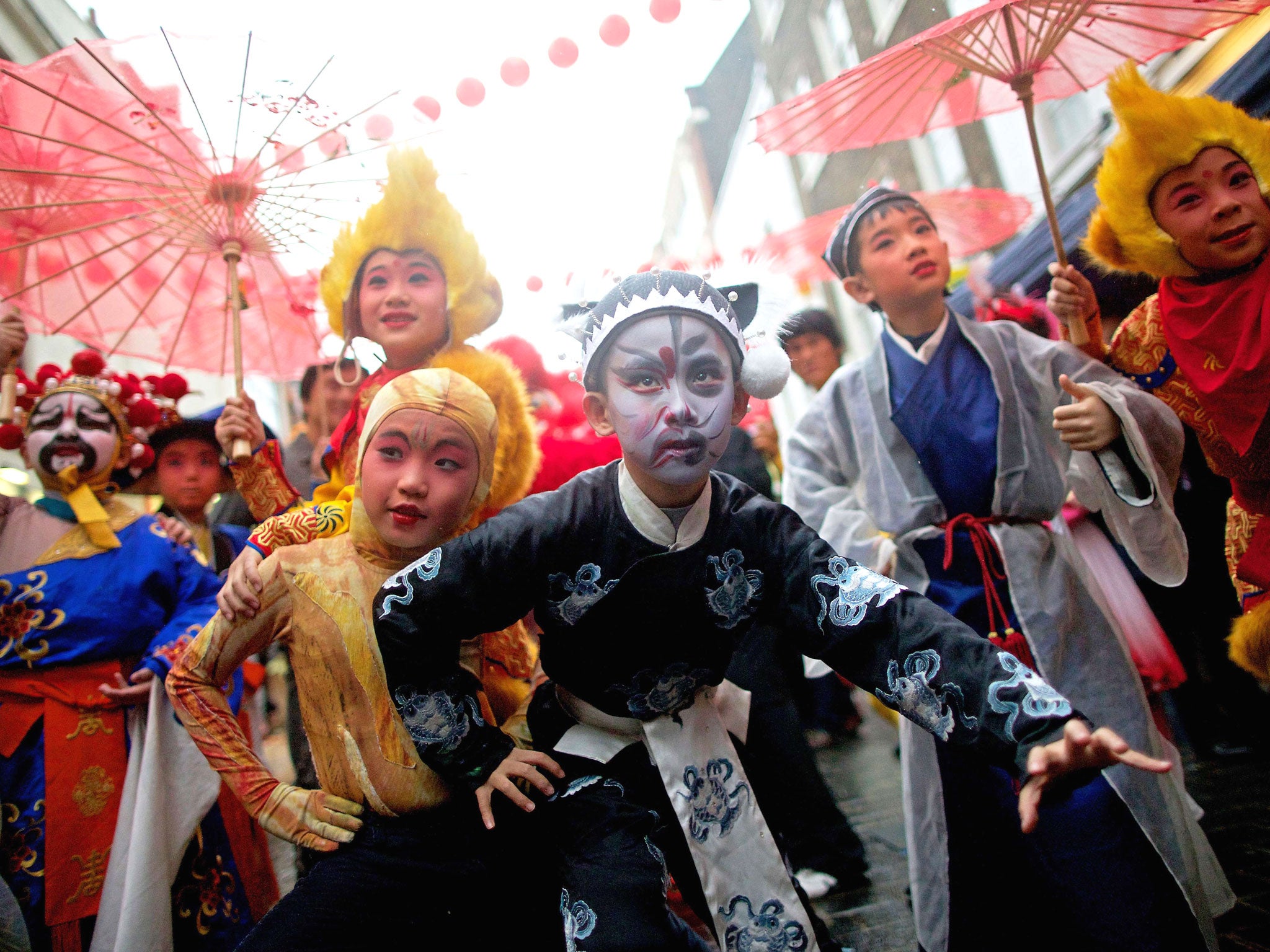 Young cultural ambassadors from Beijing dressed in traditional clothes pose for pictures during a photocall in the heart of London's Chinatown ahead of Chinese New Year celebrations