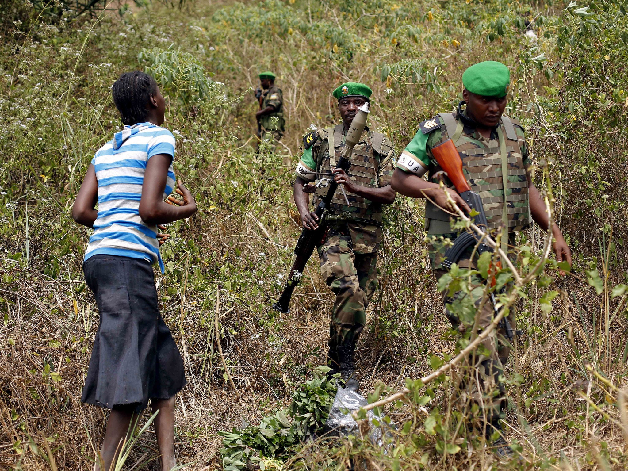 A terrified woman walks down from the bush in the hills 15 kilometers (9 miles) outside Bangui as Rwandan troops tell her to calm down during a weapons search operation (AFP/Getty Images)