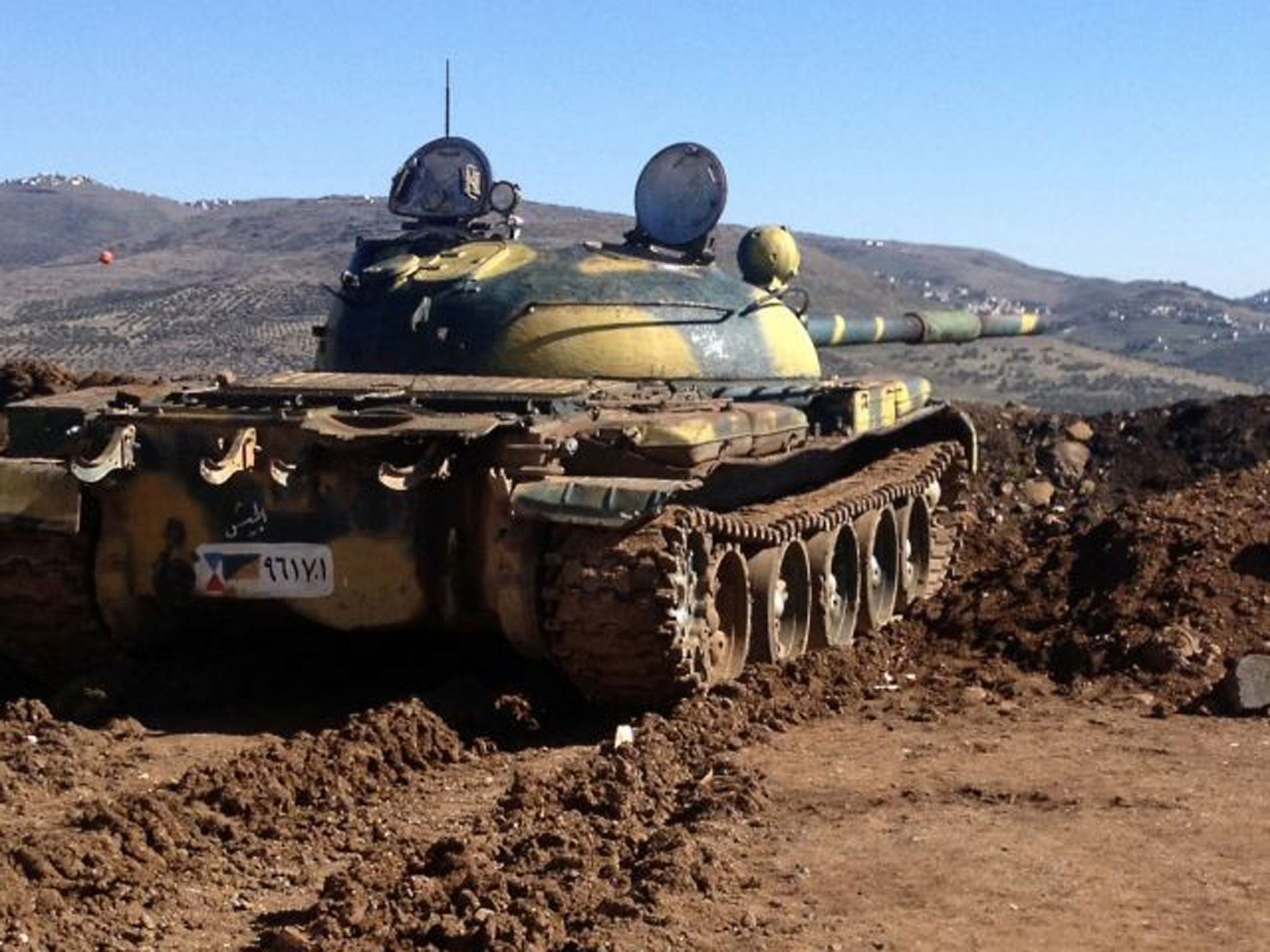 A Syrian army tank aims towards the village of Azzara, on the outskirts of Homs, at the weekend