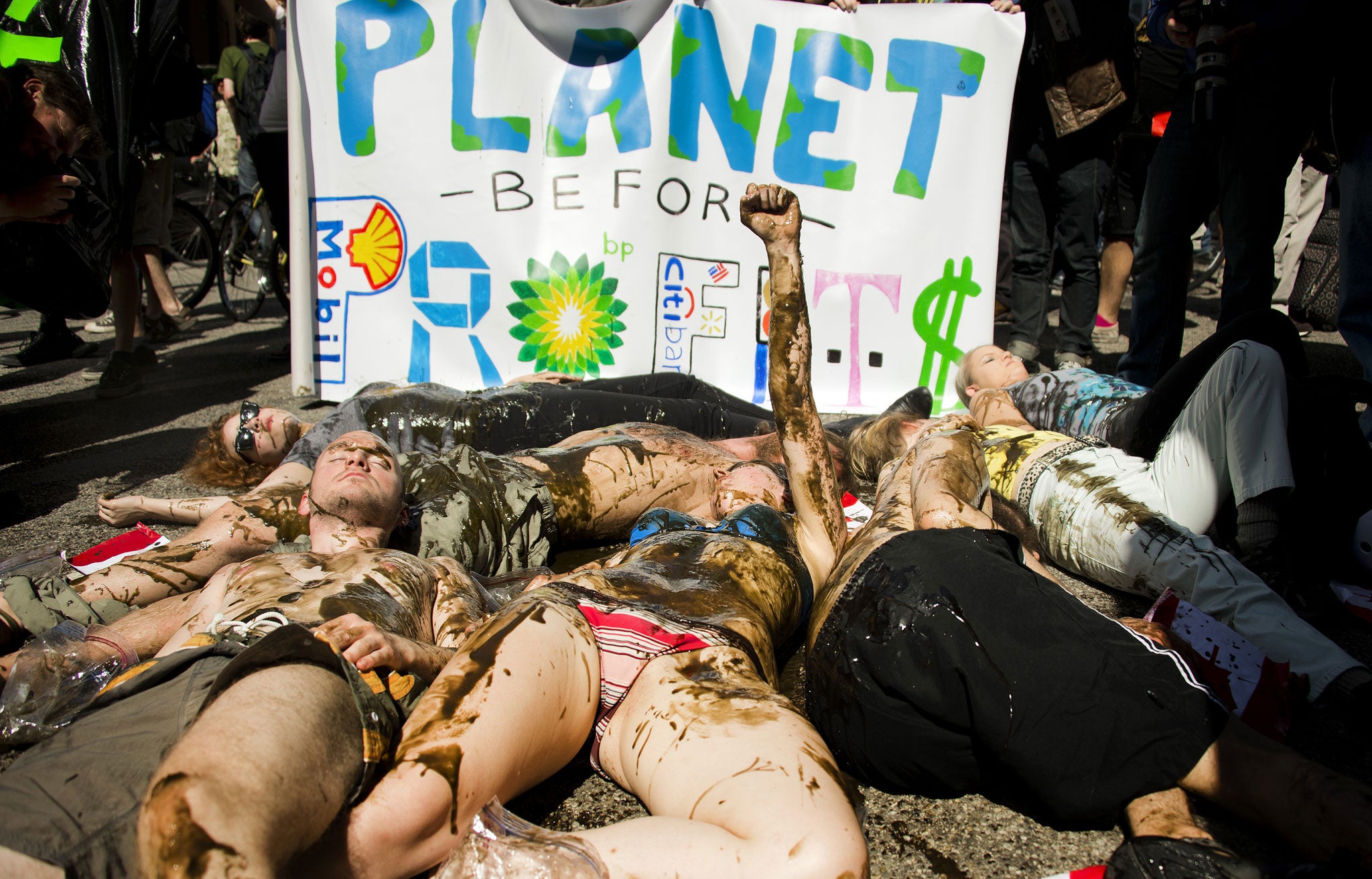 Demonstrators conduct a die-in covered in oil as they protest against the Keystone Pipline and the Alberta Tar Sands