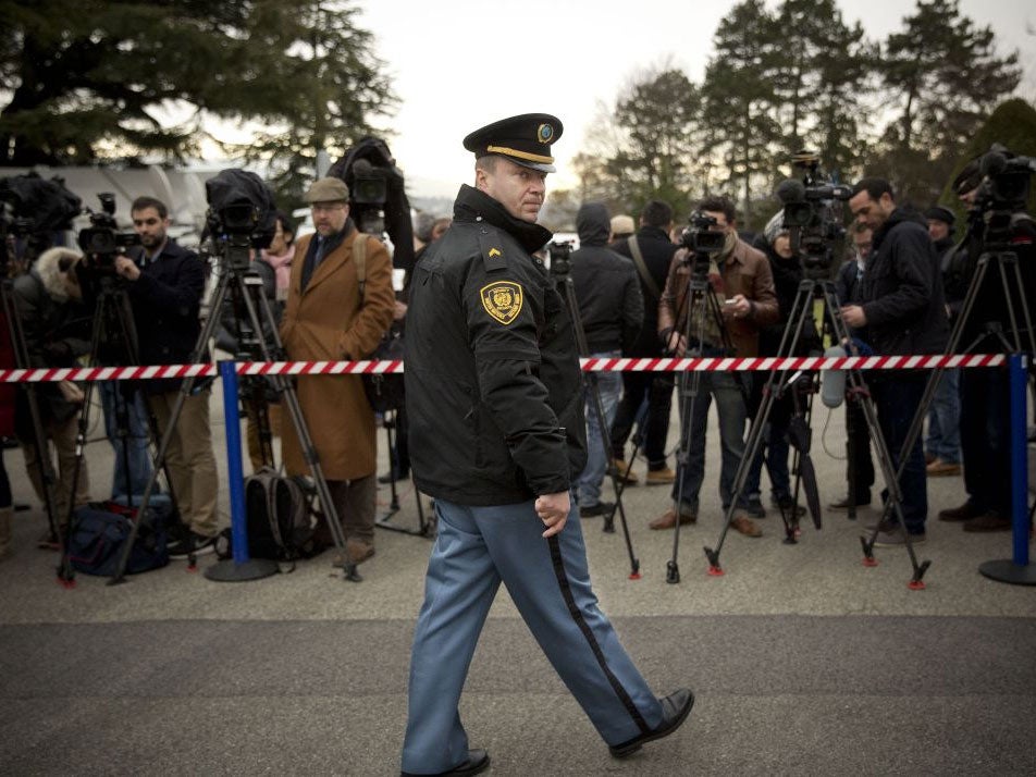 A UN security officer guards the area where journalists have gathered outside the UN headquarters in Geneva