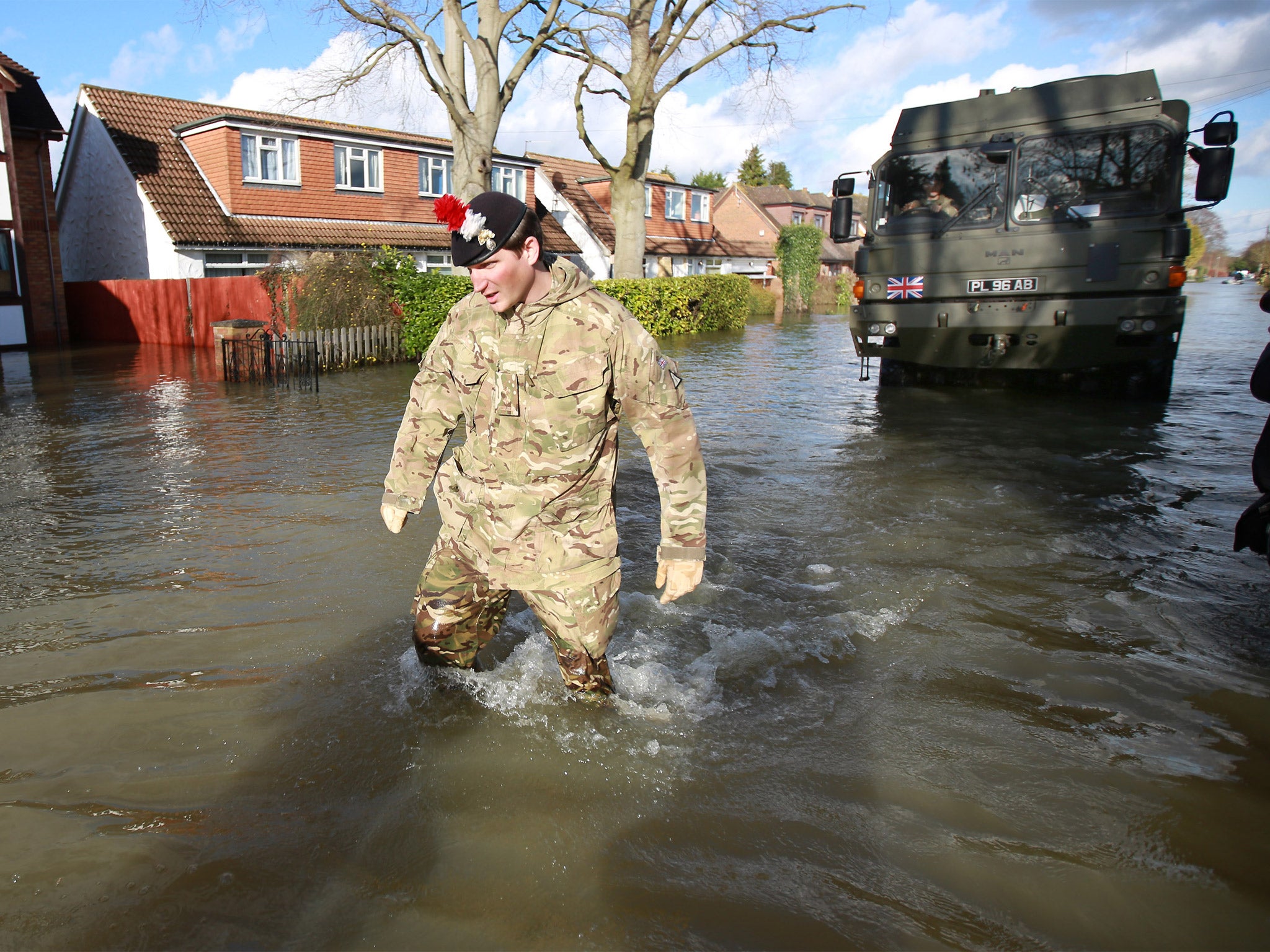 A member of the 1st Battalion of the Royal Regiment of Fusiliers leads his vehicle through flood water in Wraysbury (Getty)