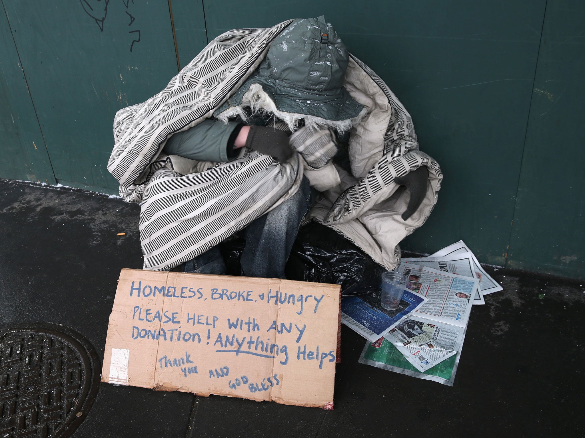 A homeless person bundles against the cold.