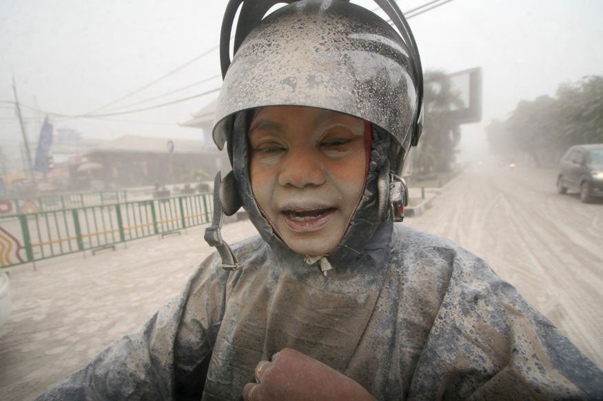 An Indonesian woman covered with ash from the Mount Kelud volcano at the roadside in Yogyakarta