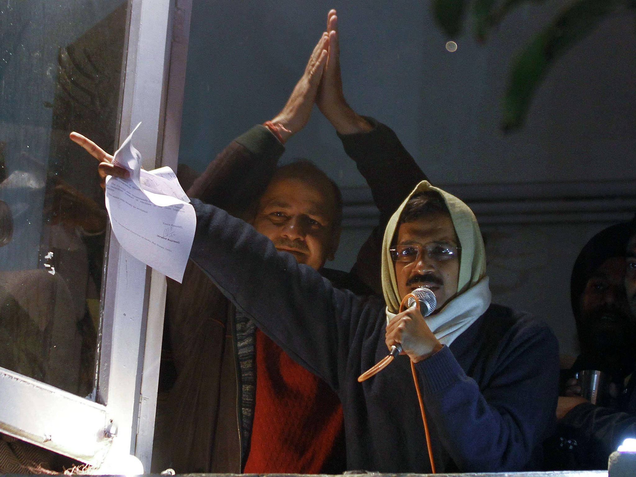 Delhi's Chief Minister Arvind Kejriwal waves his resignation letter as he addresses supporters at Aam Aadmi (Common Man) Party offices