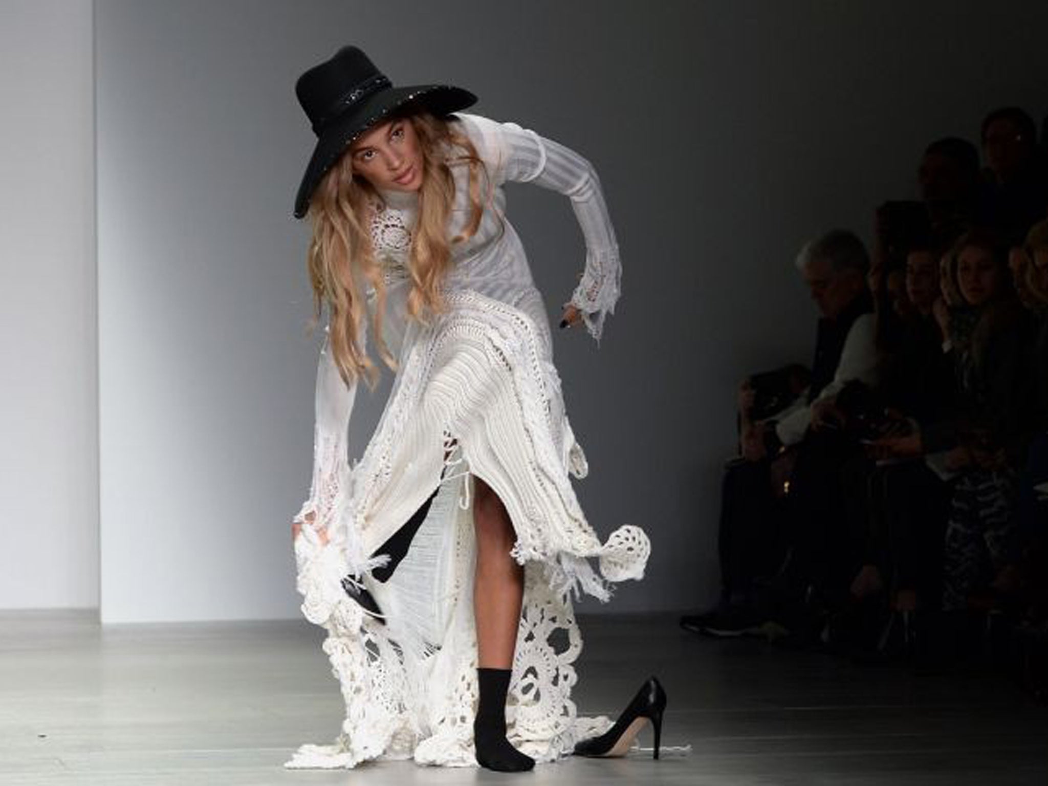 Instead of tripping and falling, the model pulls the shoes off