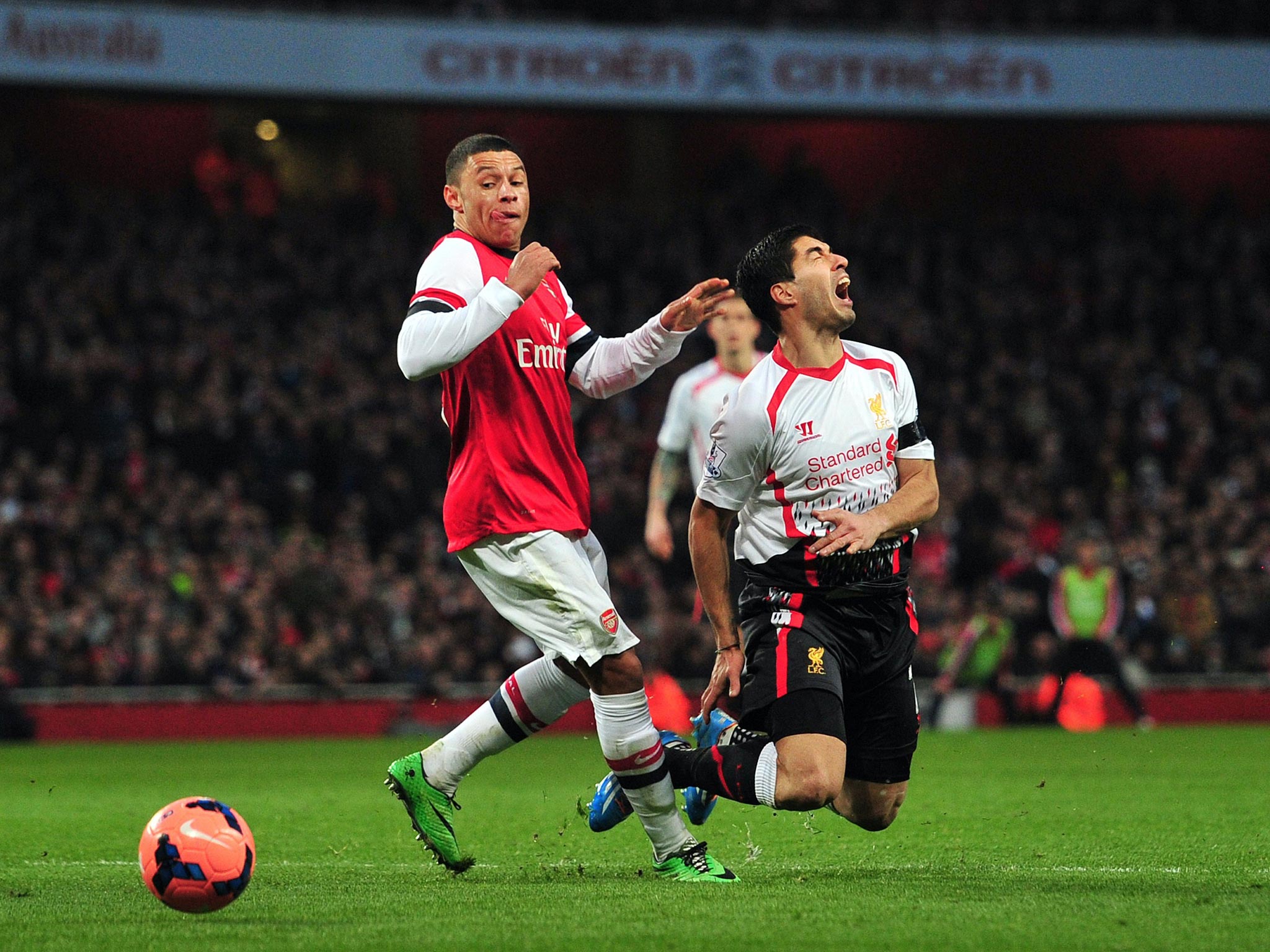 Liverpool’s Luis Suarez is brought down by Alex Oxlade-Chamblerlain but referee Howard Webb refused
to award a penalty