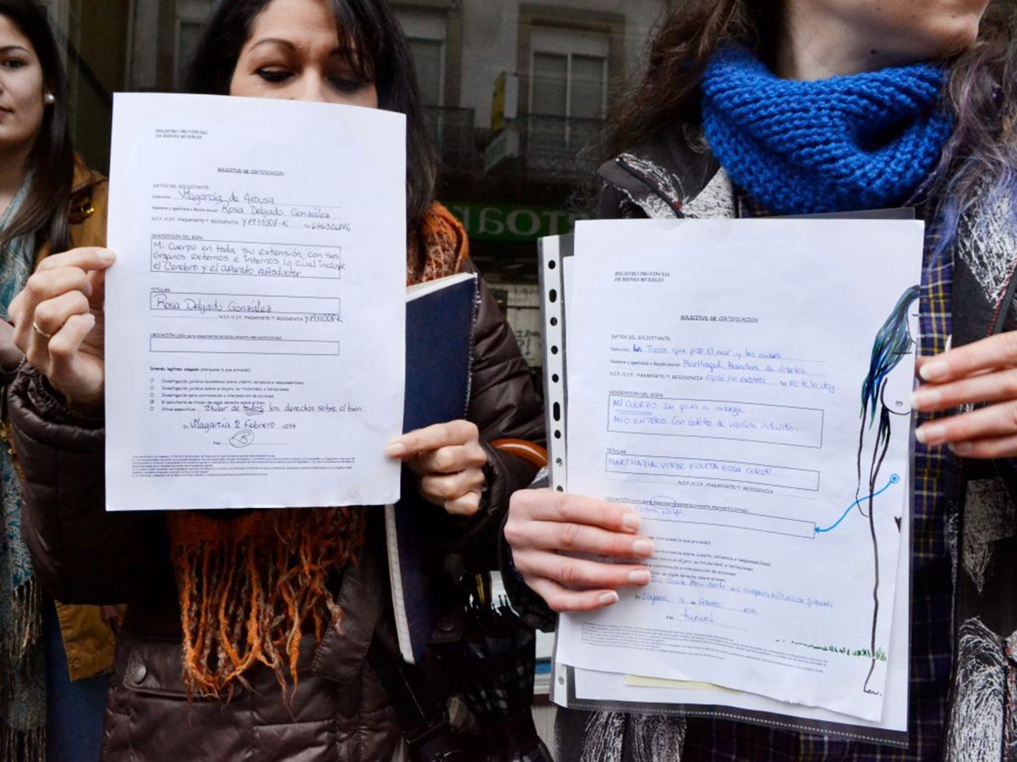 Women show off their paperwork outside a register office after officially declaring their bodies to be private property