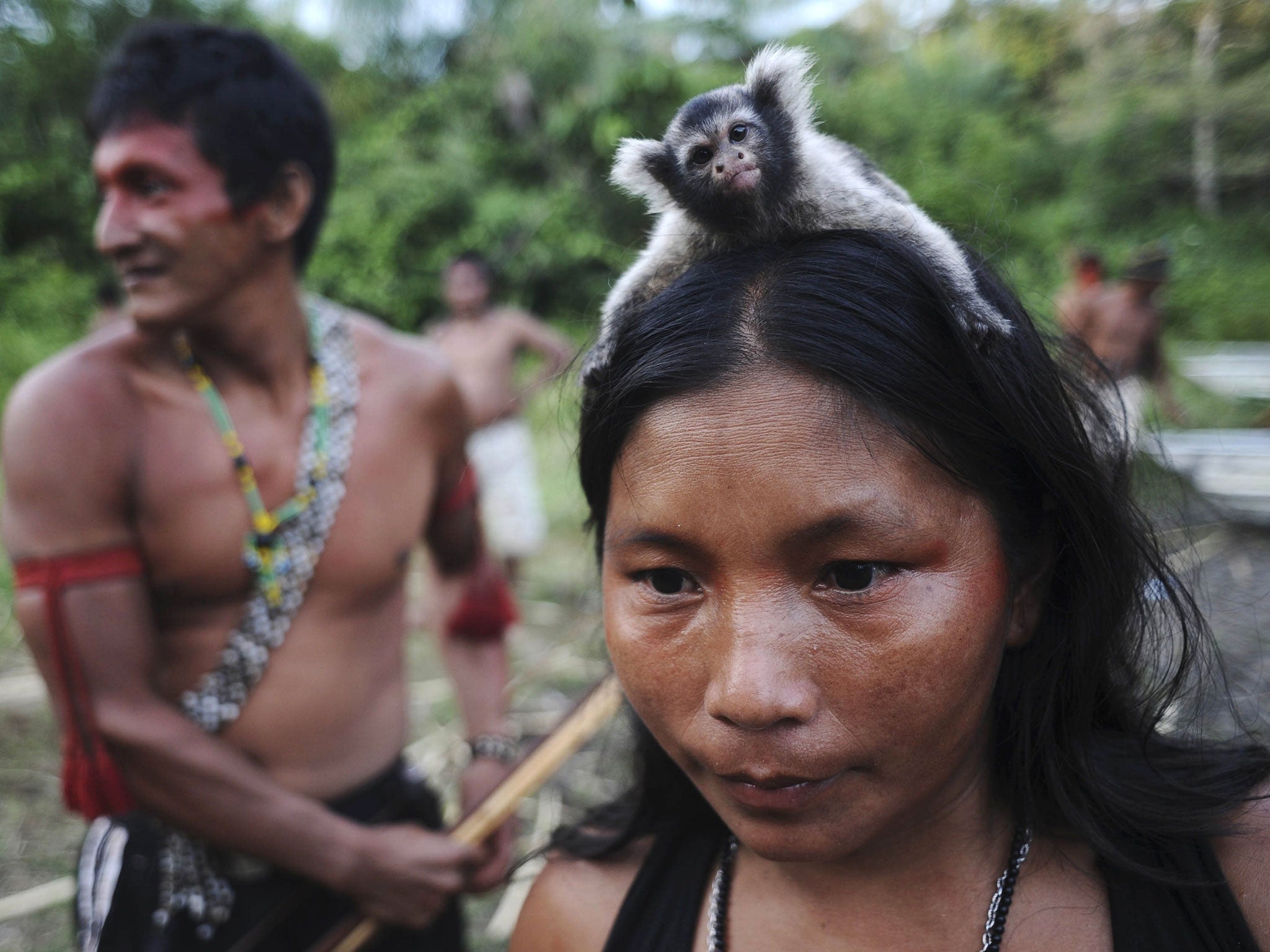A Munduruku Indian woman warrior carries a monkey on her head while on a search for illegal gold mines and miners in their territory, near the Kadiriri river