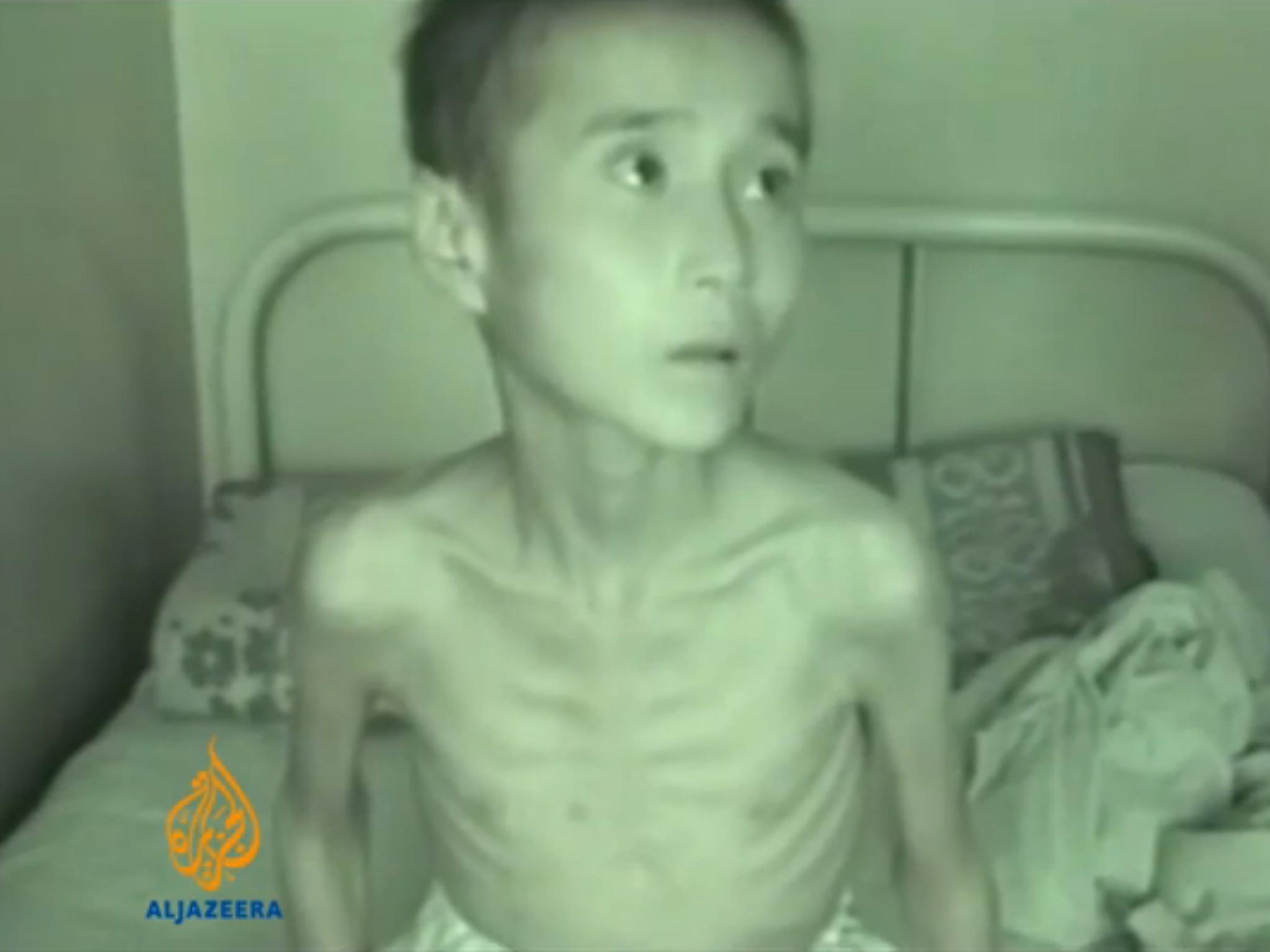 An emaciated boy sits on a bed in shocking footage of how North Korea treats its citizens