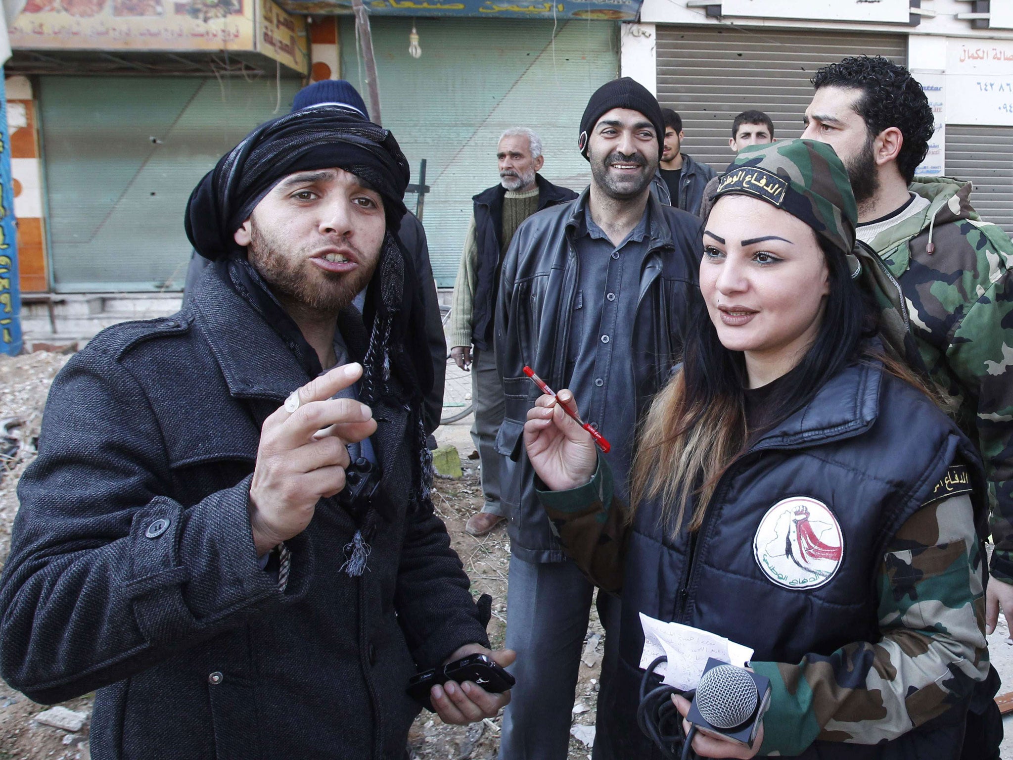 A rebel fighter speaks to a woman wearing military fatigues in Babilla during a ceasefire