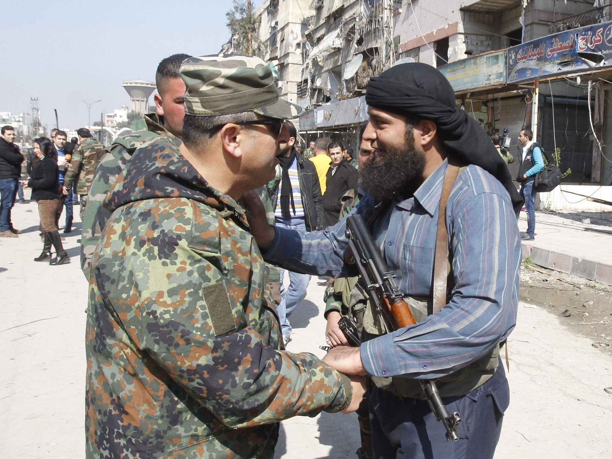 A member of Syria’s armed opposition forces chats with an officer from the forces loyal to Syria’s President Bashar al-Assad in Babilla town, south-east Damascus, after a local ceasefire agreement was reached