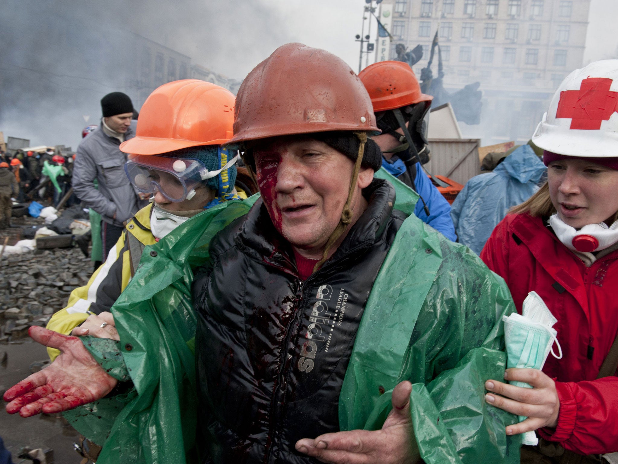 A wounded protester is evacuated during clashes in Independence Square