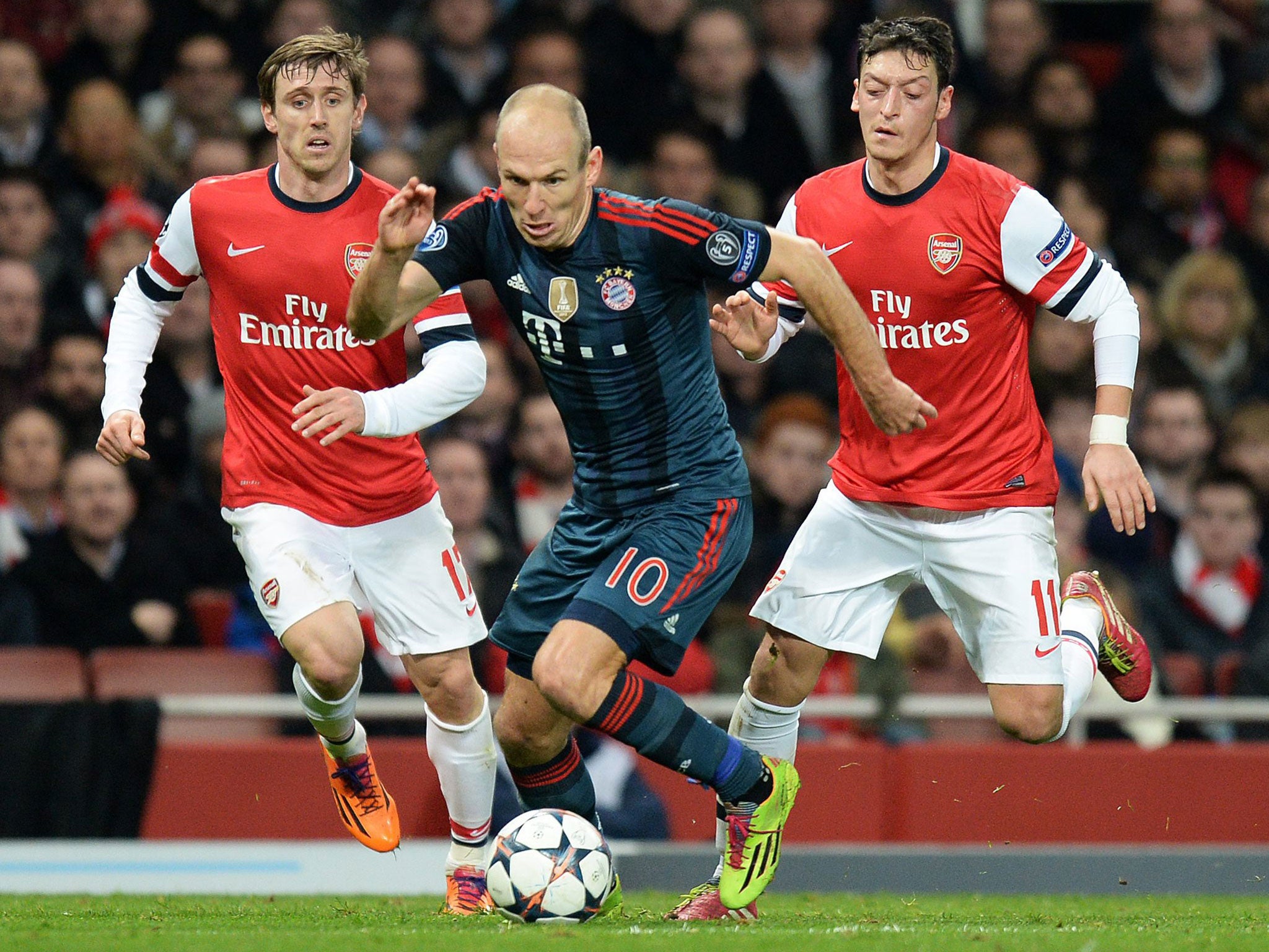 Bayern Munich's Arjen Robben, centre, skips past Arsenal's Nacho Monreal, left, and Mesut Ozil, right