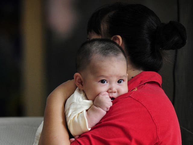 This file photo taken on September 23, 2008 shows a mother holding her baby at a children's hospital in Beijing as China's toxic milk scandal escalated after officials admitted nearly 53,000 children had been sickened by contaminated products. The former boss of the dairy firm at the heart of China's milk scandal, Sanlu Group, was on January 22, 2009 sentenced to life in jail, state media reported. Tian Wenhua, 66, former head of the Sanlu Group, received life imprisonment while three of her colleagues were given sentences ranging from five to 15 years. Meanwhile another Chinese court sentenced two men to death for making and selling some of the tainted milk that killed six babies and sickened nearly 300,000 others, state media reported.