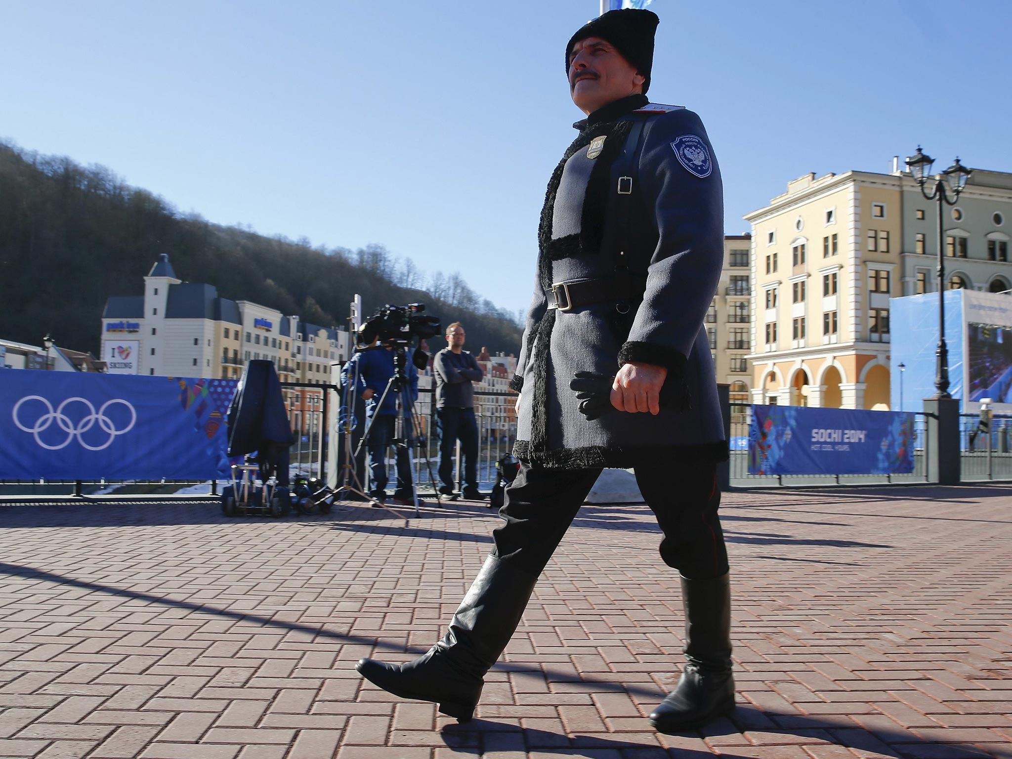 A Cossack in traditional attire walks through downtown Rosa Khutor