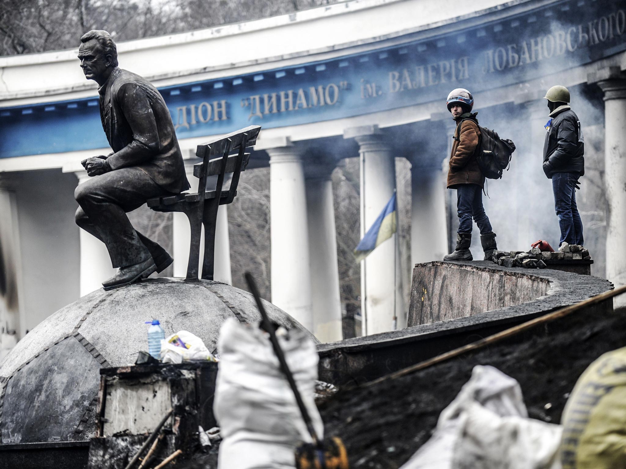 Anti-government protesters stand on a barricade at the entrance of Kiev's Independence square