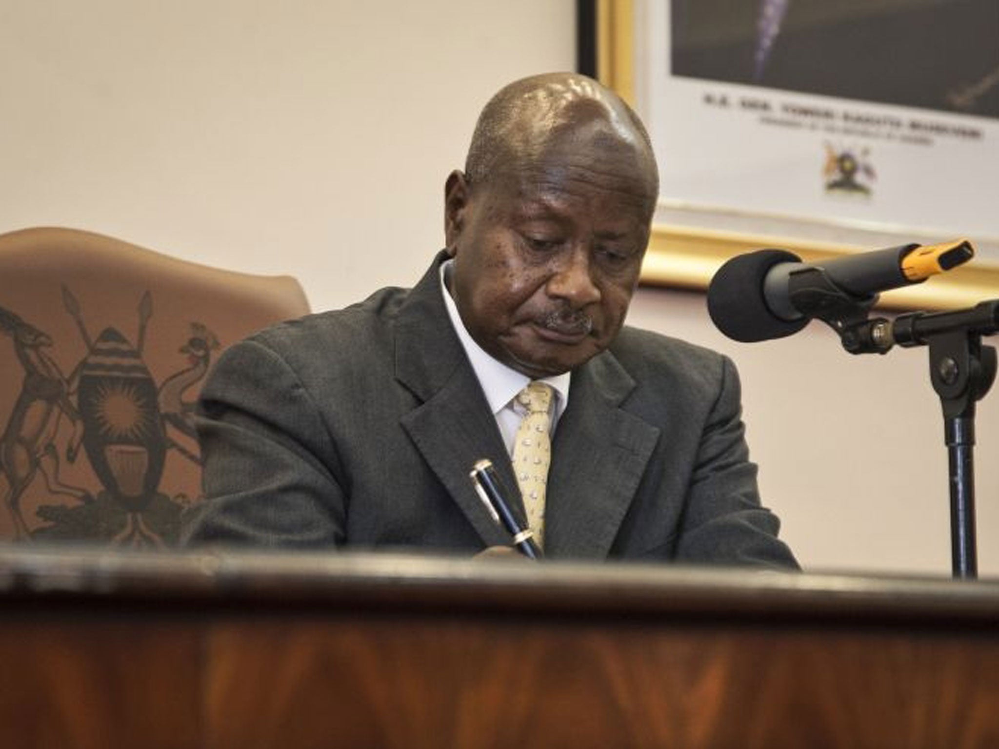 Uganda's President Yoweri Museveni signs a new anti-gay bill that sets harsh penalties for homosexual sex, in Entebbe, Uganda Monday, Feb. 24, 2014.