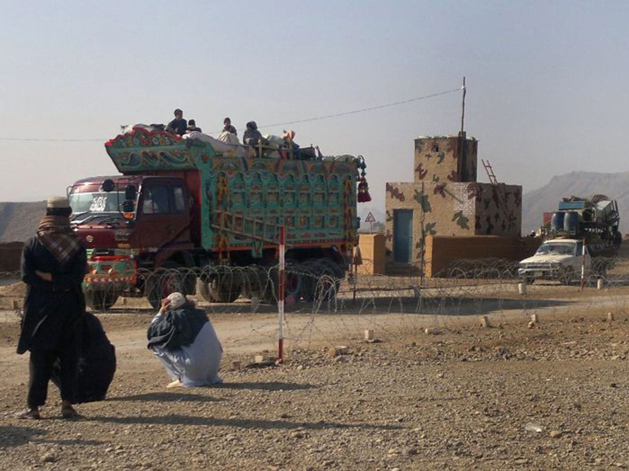 Pakistani tribal families cross a military check post as they flee after air strikes on Taliban hideouts