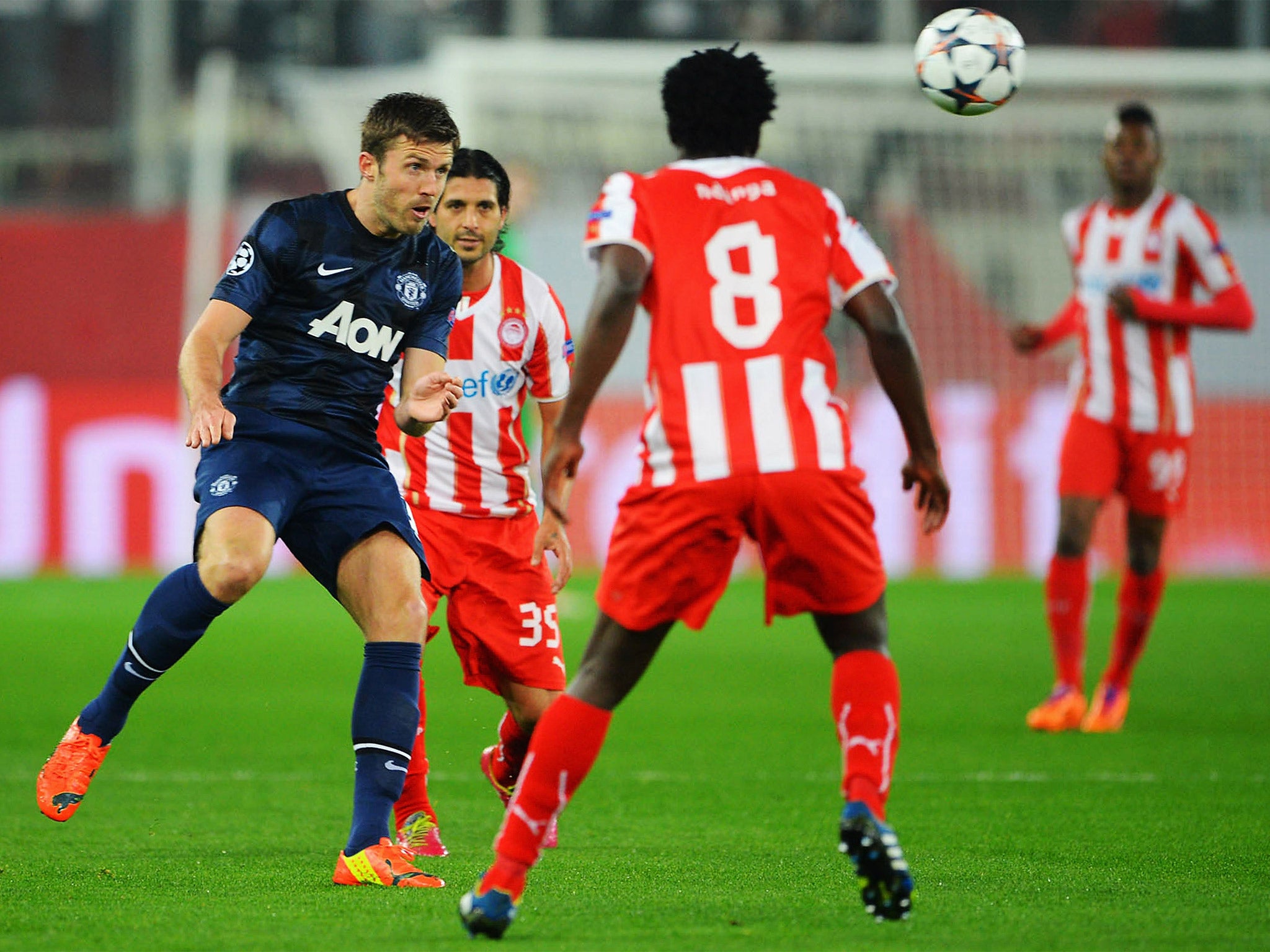 Michael Carrick heads the ball forward against Olympiakos