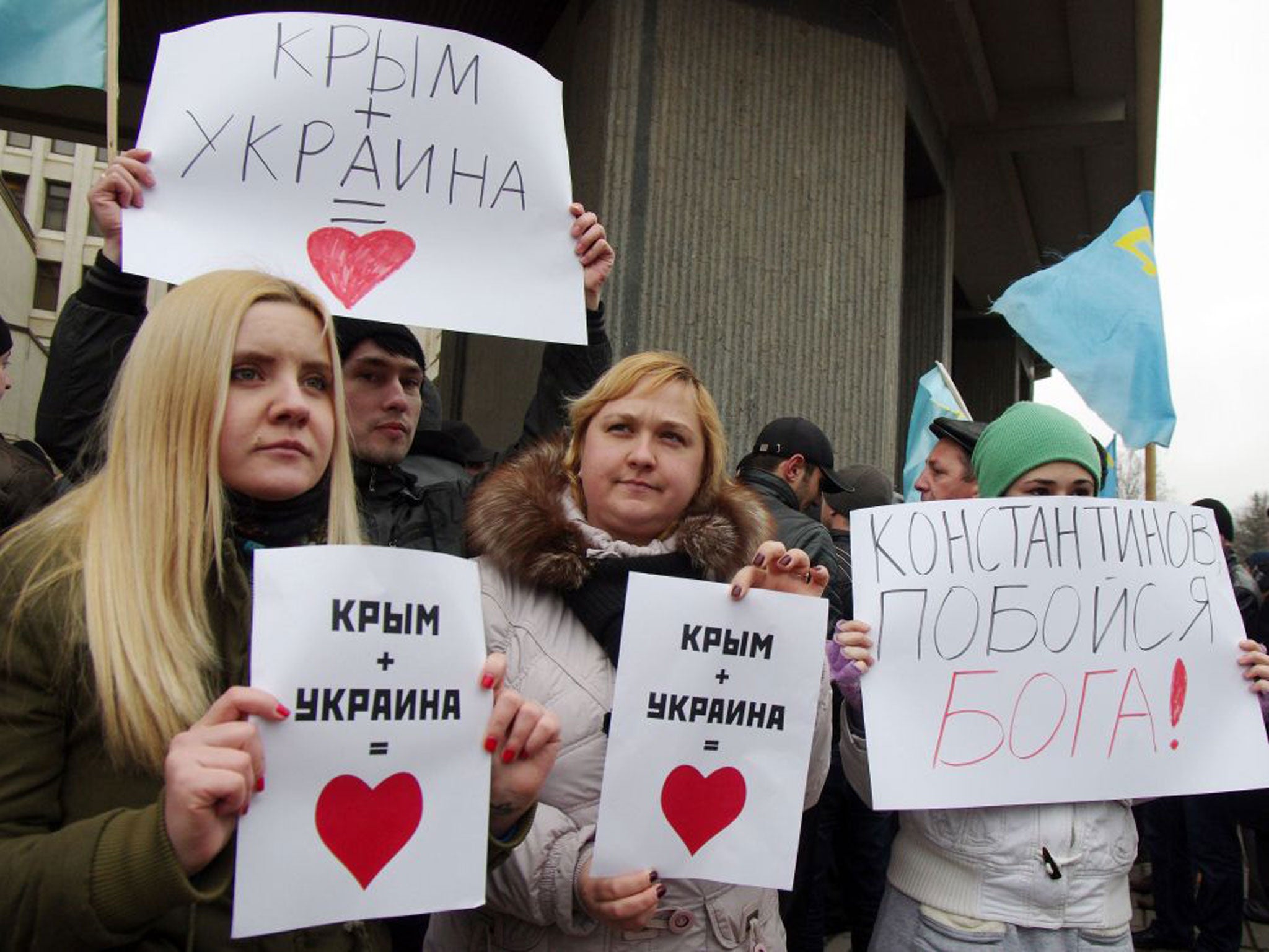 Pro-Ukrainian activists hold placards reading "Crimea +Ukraine is love" during a rally in front of the Crimean parliament in Semfiropol