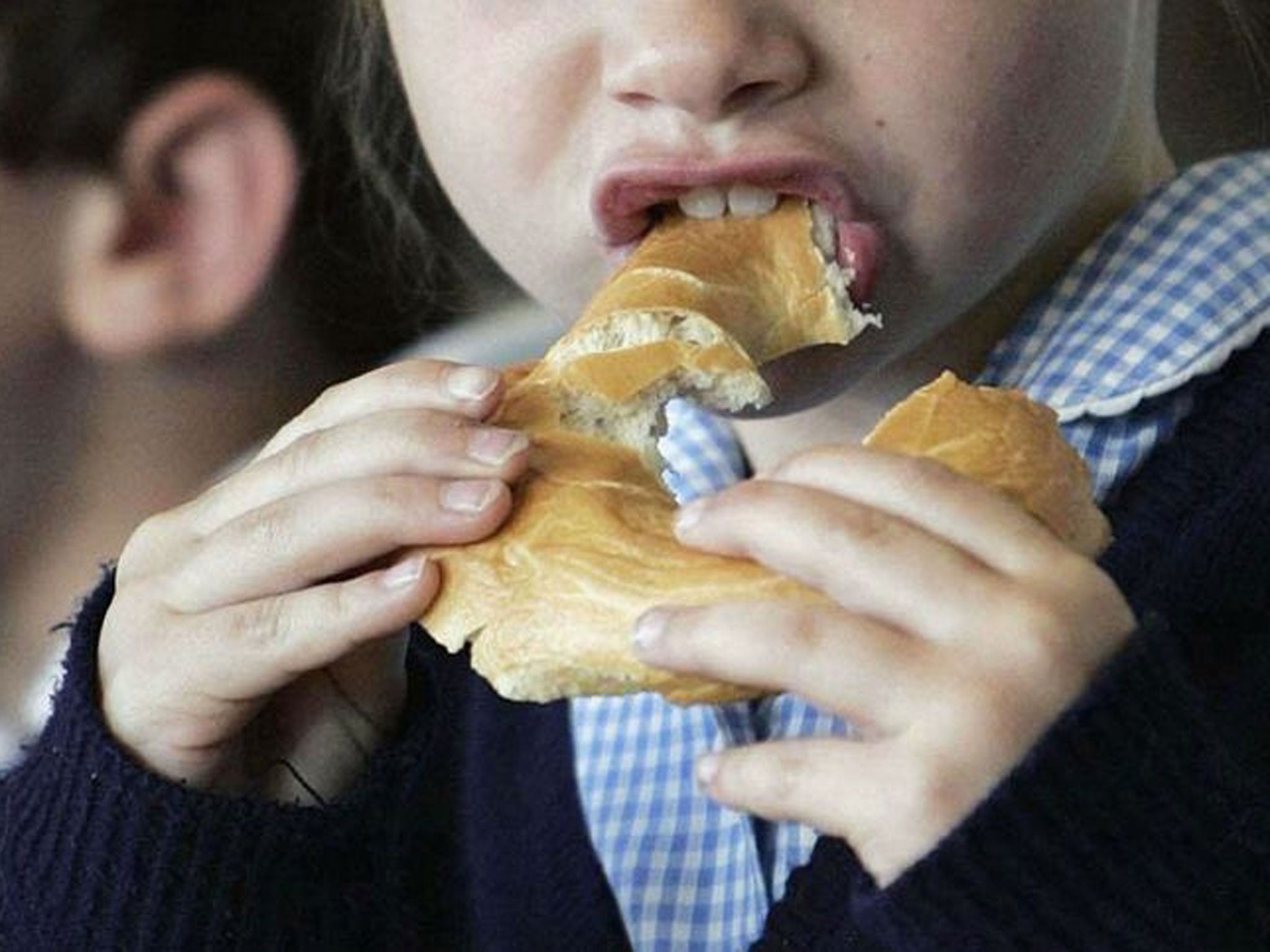 A child eating a bagel at a breakfast club.