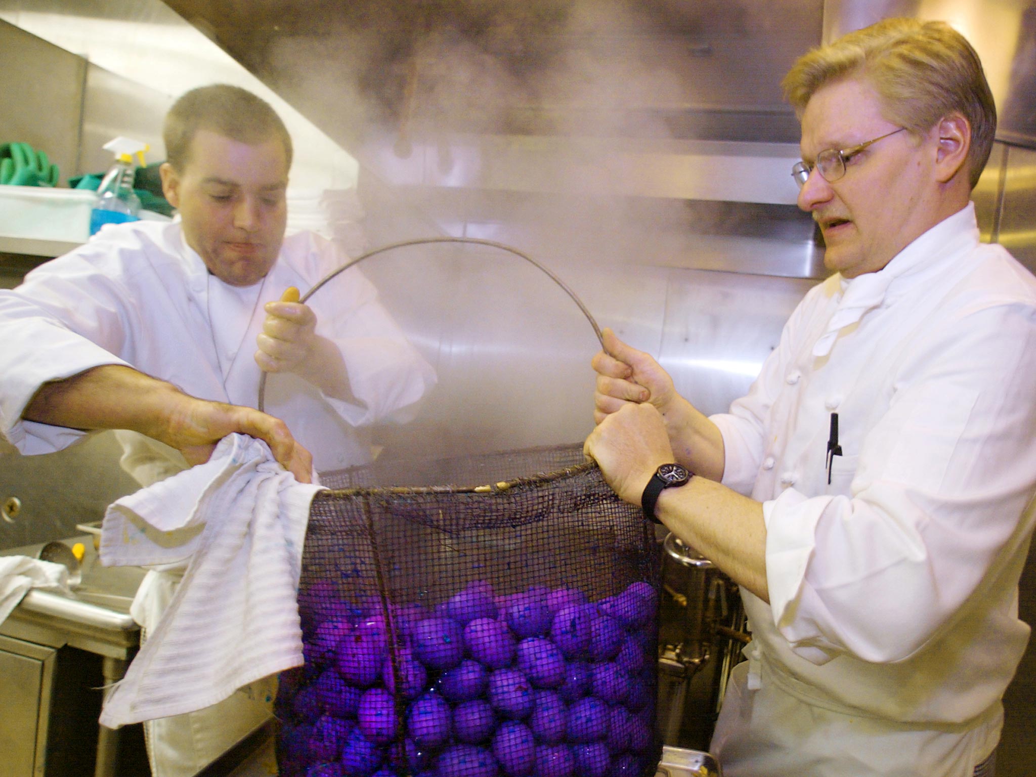 White House chefs Randy Chamblee (left) and John Moeller lift a basket of hot, steamy blue eggs in the kitchen