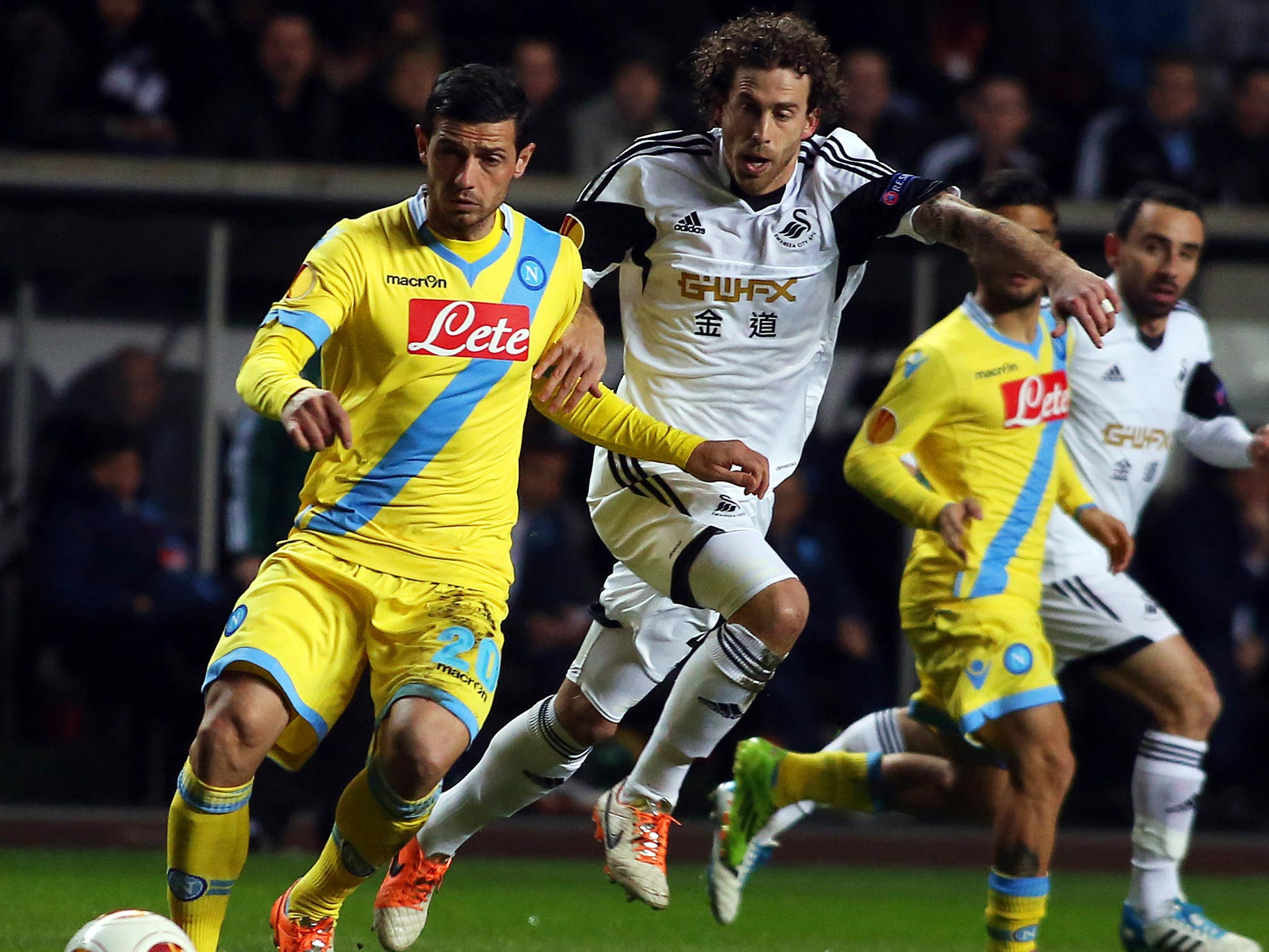 Swansea City's Spanish midfielder Jose Alberto Canas (C) clears the ball under pressure from Napoli's Slovakian midfielder Marek Hamsik (R) and Napoli's Swiss midfielder Blerim Dzemaili (L)